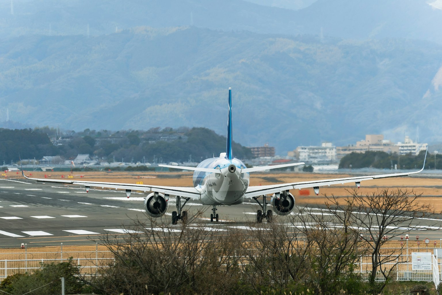 Flugzeug rollt auf der Landebahn mit Bergen im Hintergrund