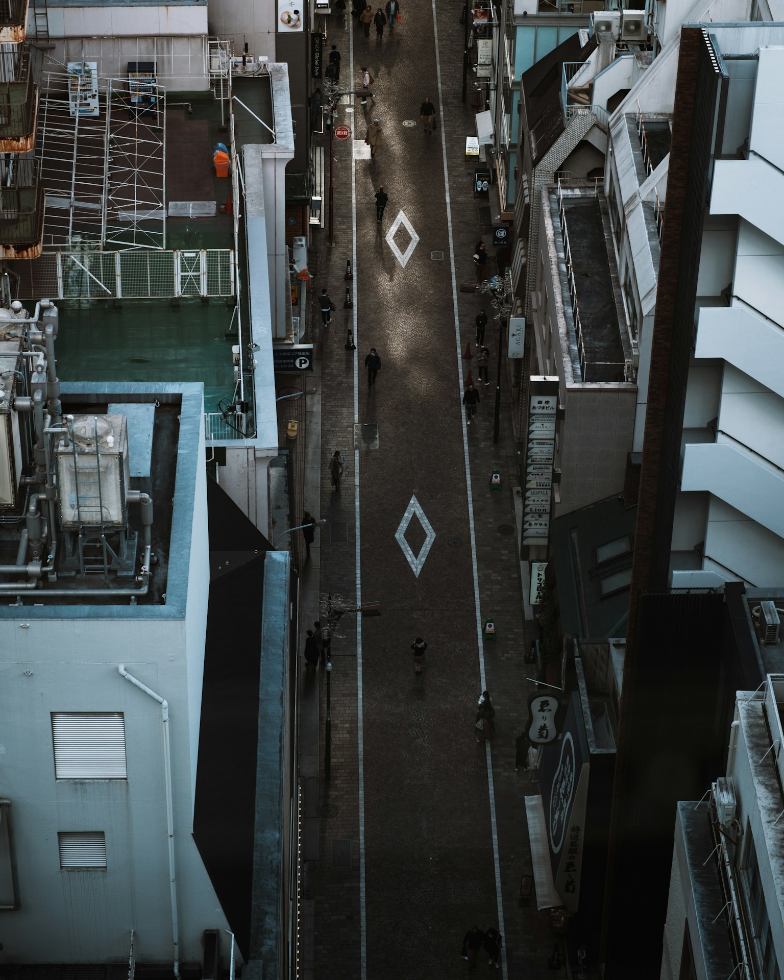 Vista aérea de una calle de la ciudad con edificios alineados y patrones de diamante en el pavimento
