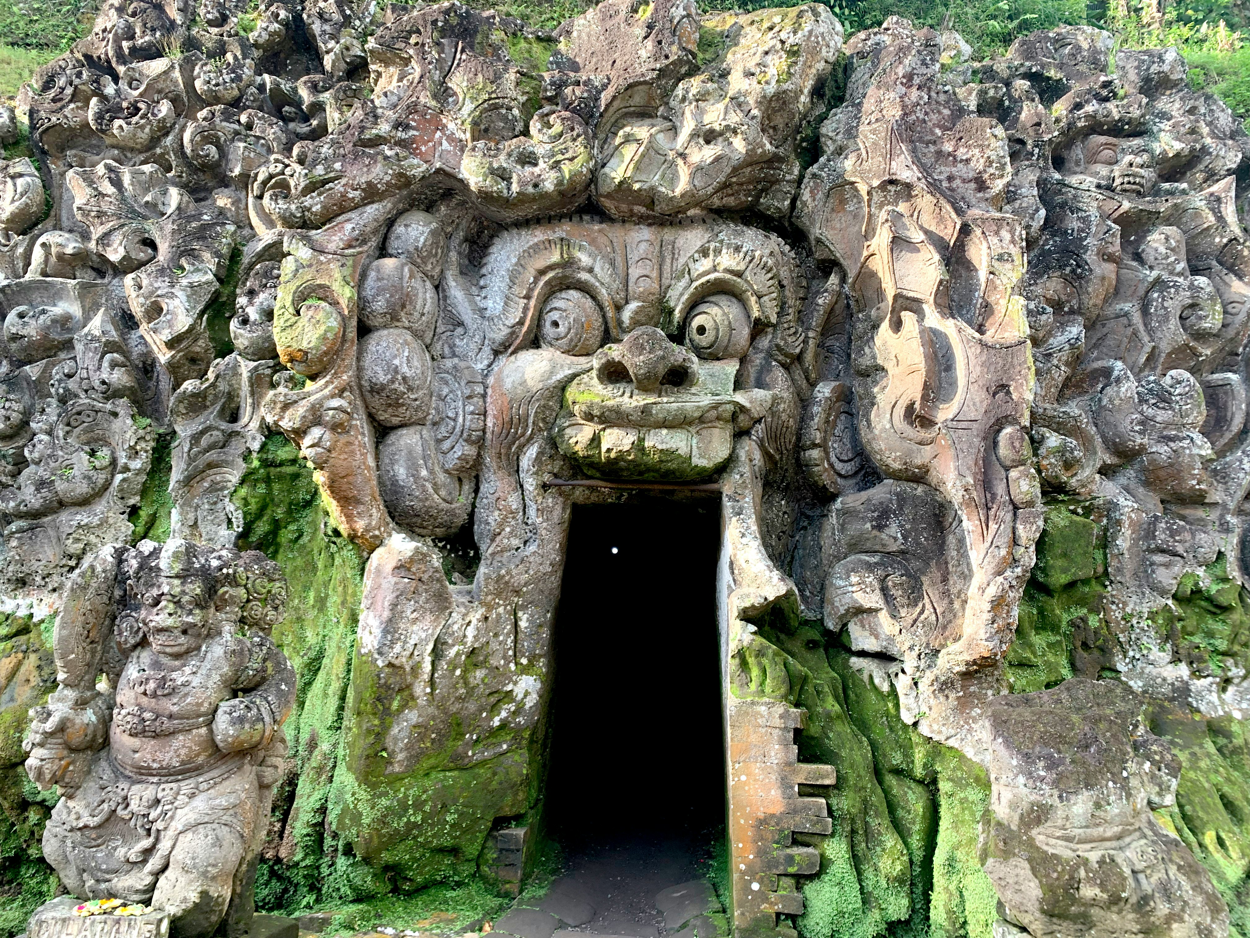 石彫りの獅子と仏像が並ぶ洞窟風の寺院入口