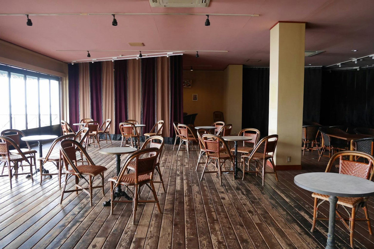 Geräumiges Café-Interieur mit Holzboden und angeordneten Tischen und Stühlen