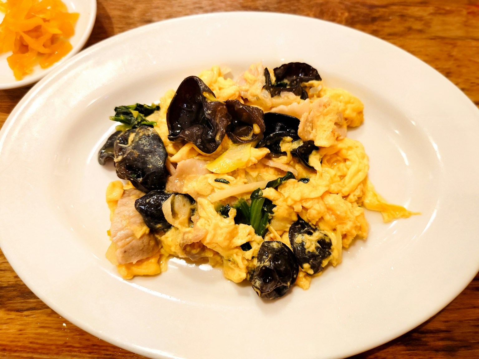 A plate of scrambled eggs with shellfish and herbs