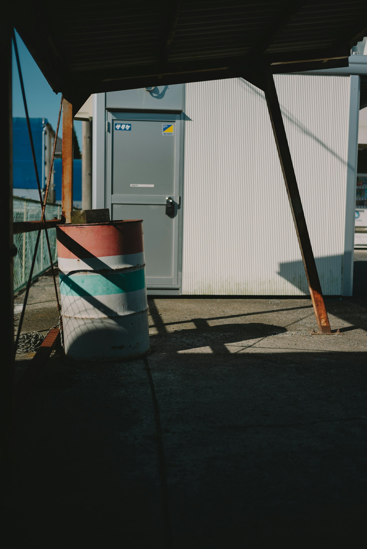 Scène industrielle avec un baril coloré et une porte