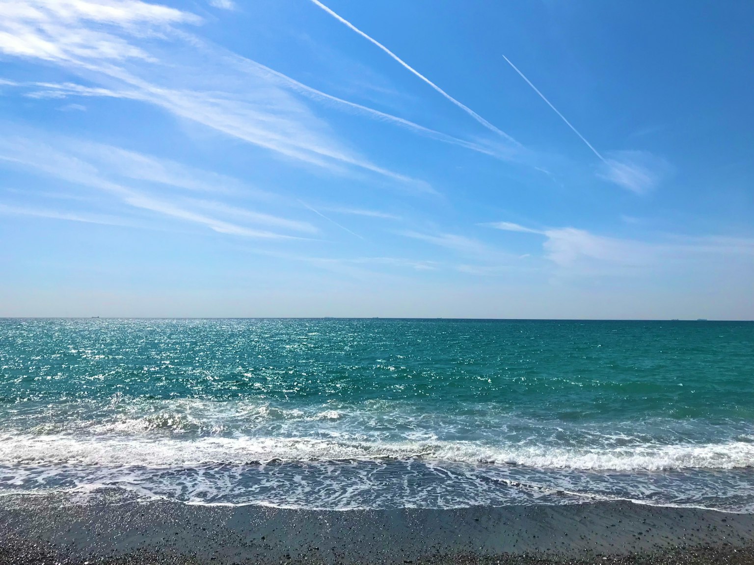 藍色海洋和晴朗天空的風景柔和的波浪拍打在海岸上