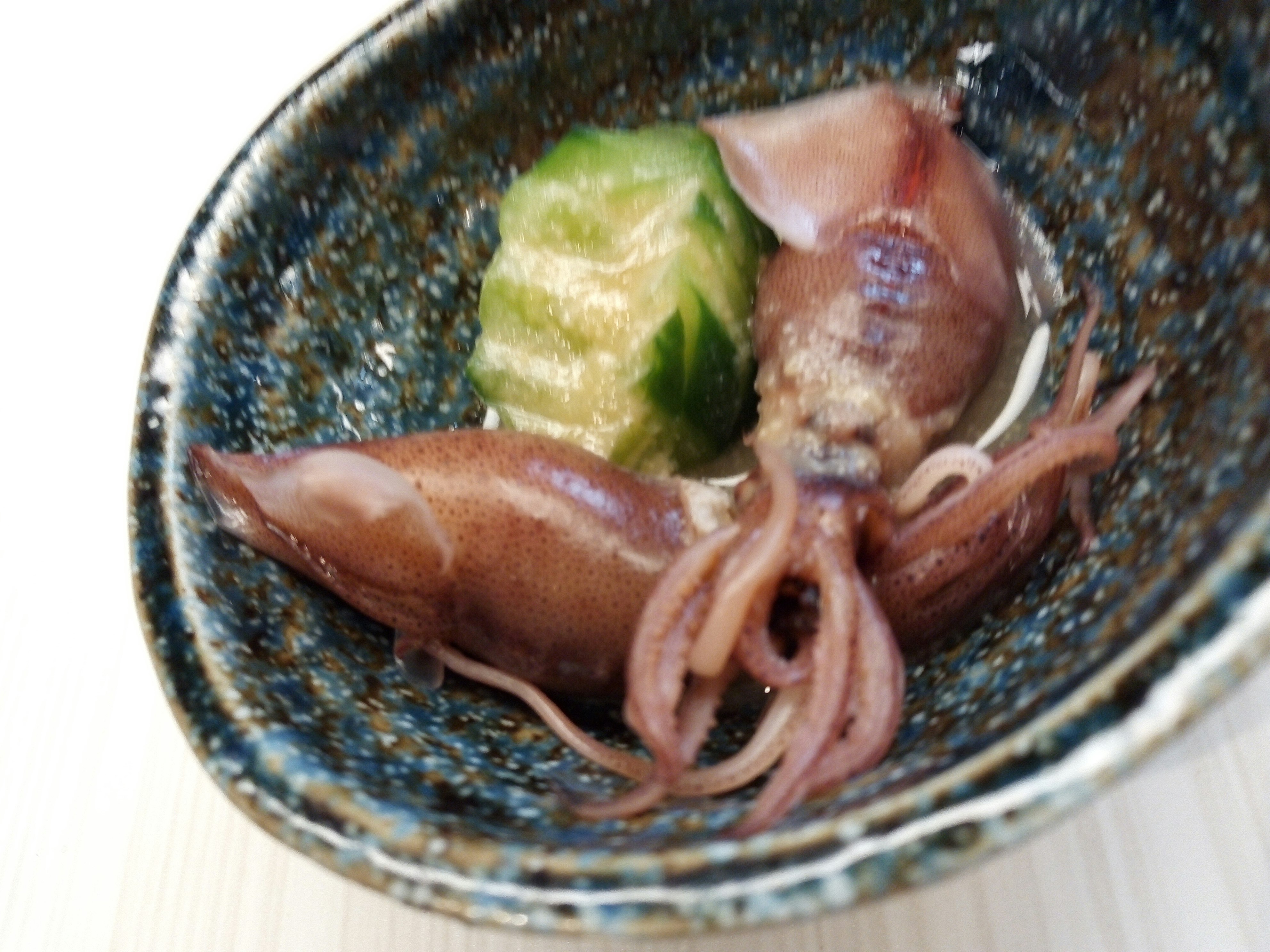 sliced squid sashimi in a blue-rimmed bowl