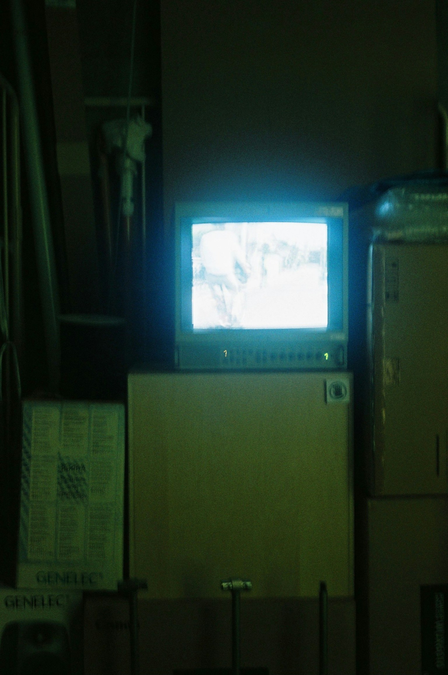 Televisión antigua emitiendo una luz azulada en una habitación poco iluminada