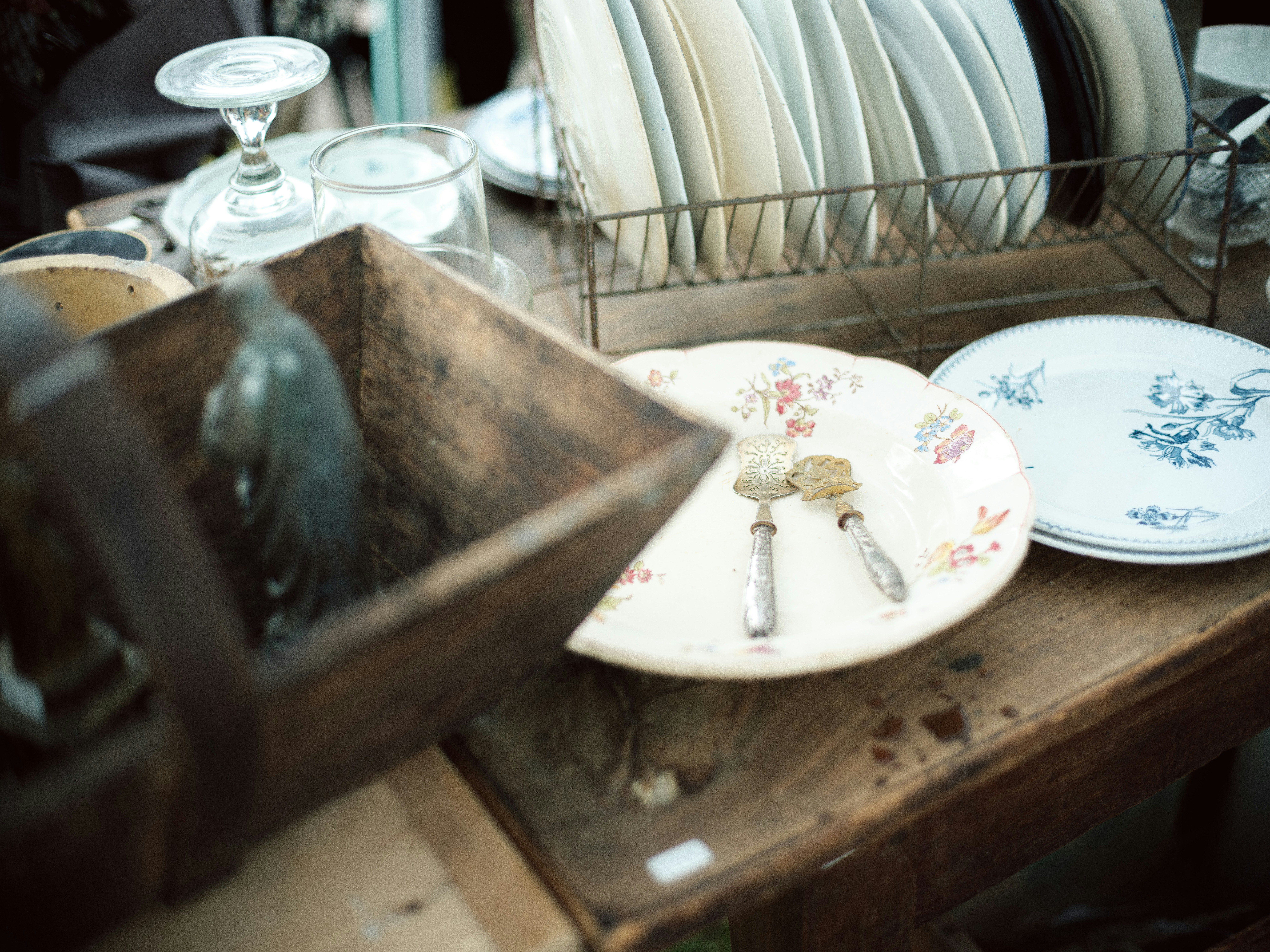 corner of a wooden table with vintage dishware at a flea market