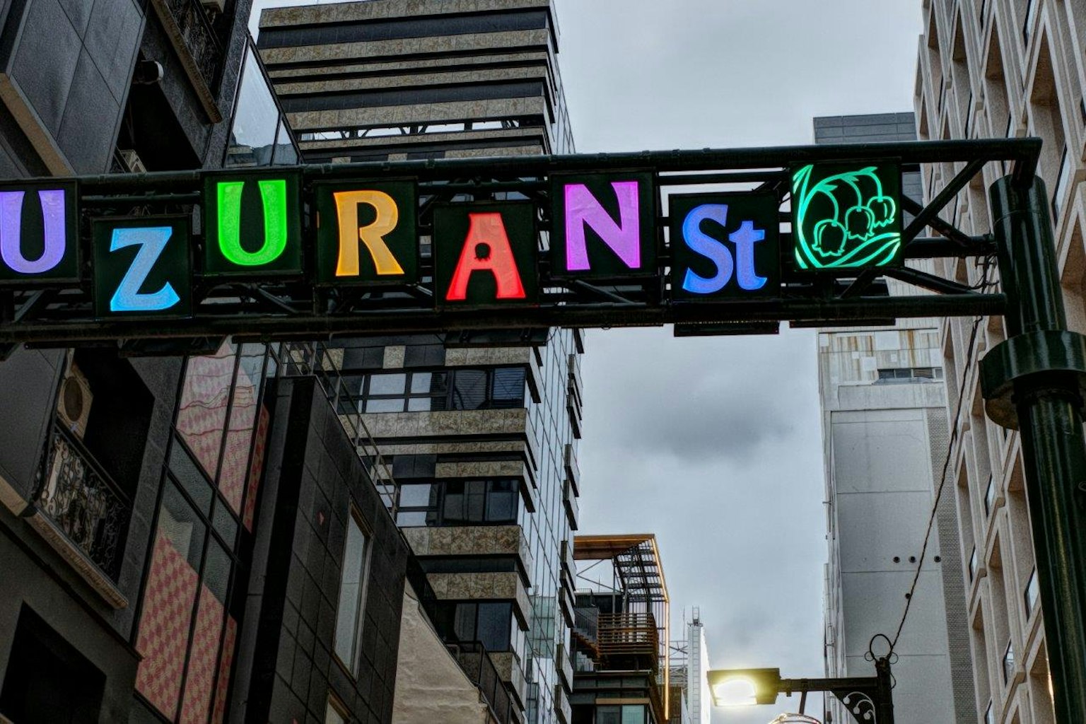 色彩繽紛的標誌上寫著'UZURAN St'，背景是現代建築