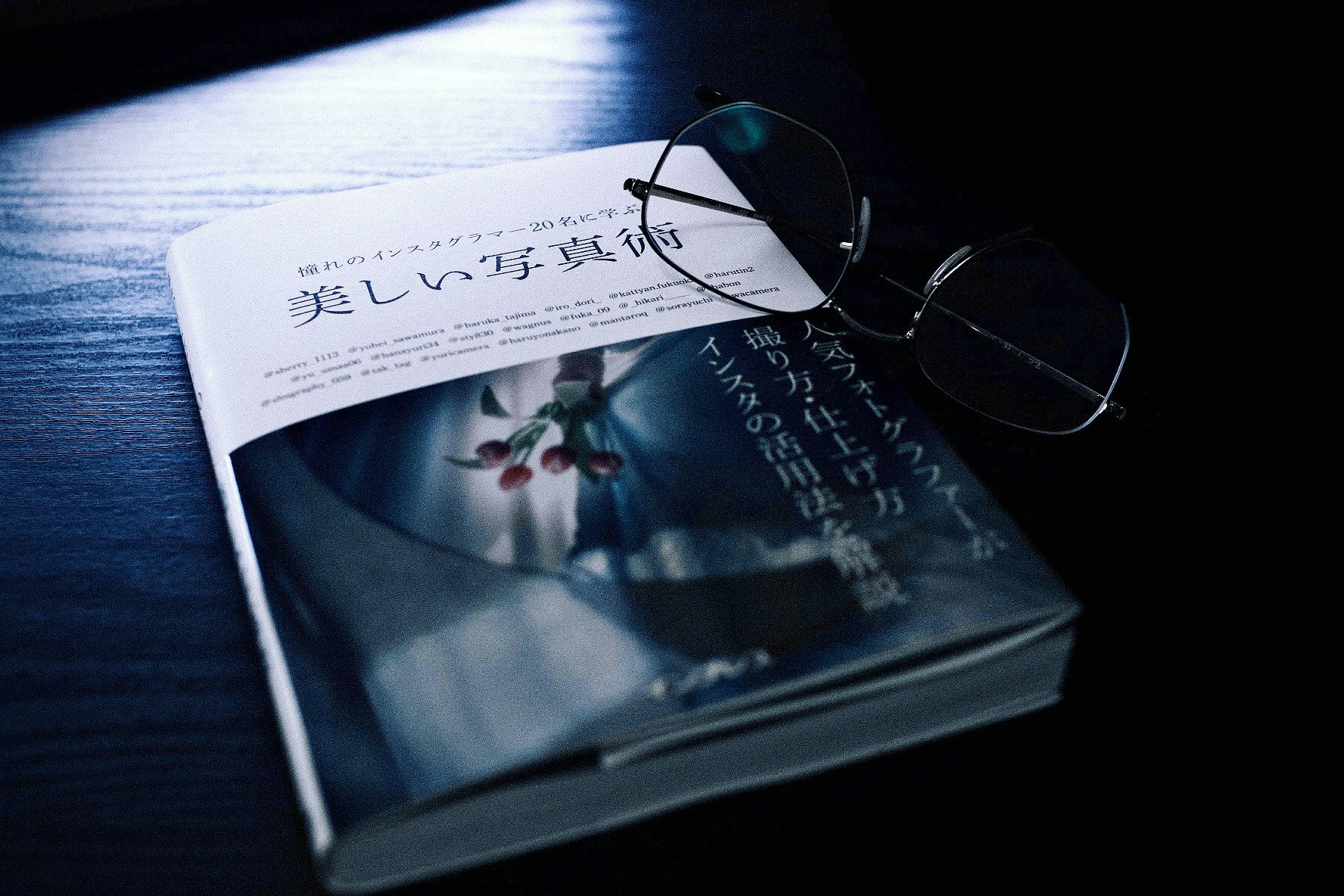 Buch und Brille auf blauem Schreibtisch