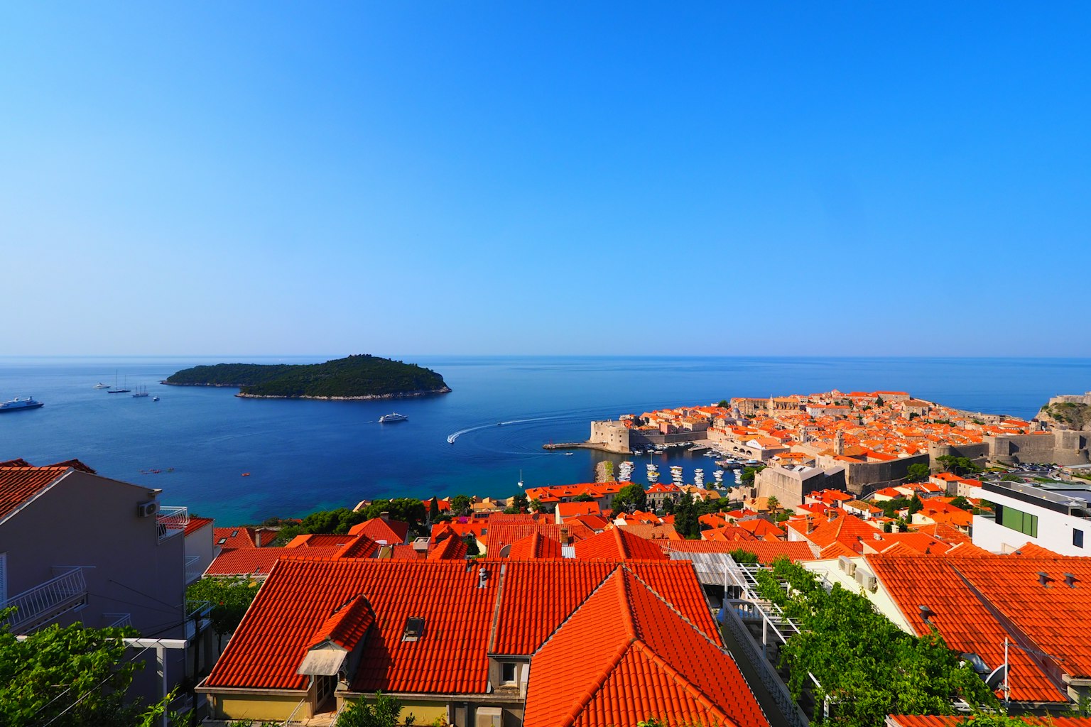 Pemandangan panorama Dubrovnik dengan rumah atap merah di bawah langit biru dan laut