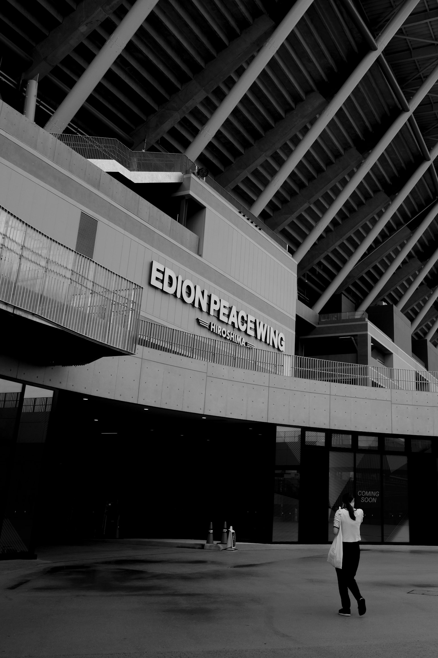 Black and white image of Edion Peace Plaza showcasing its architectural design with a person walking