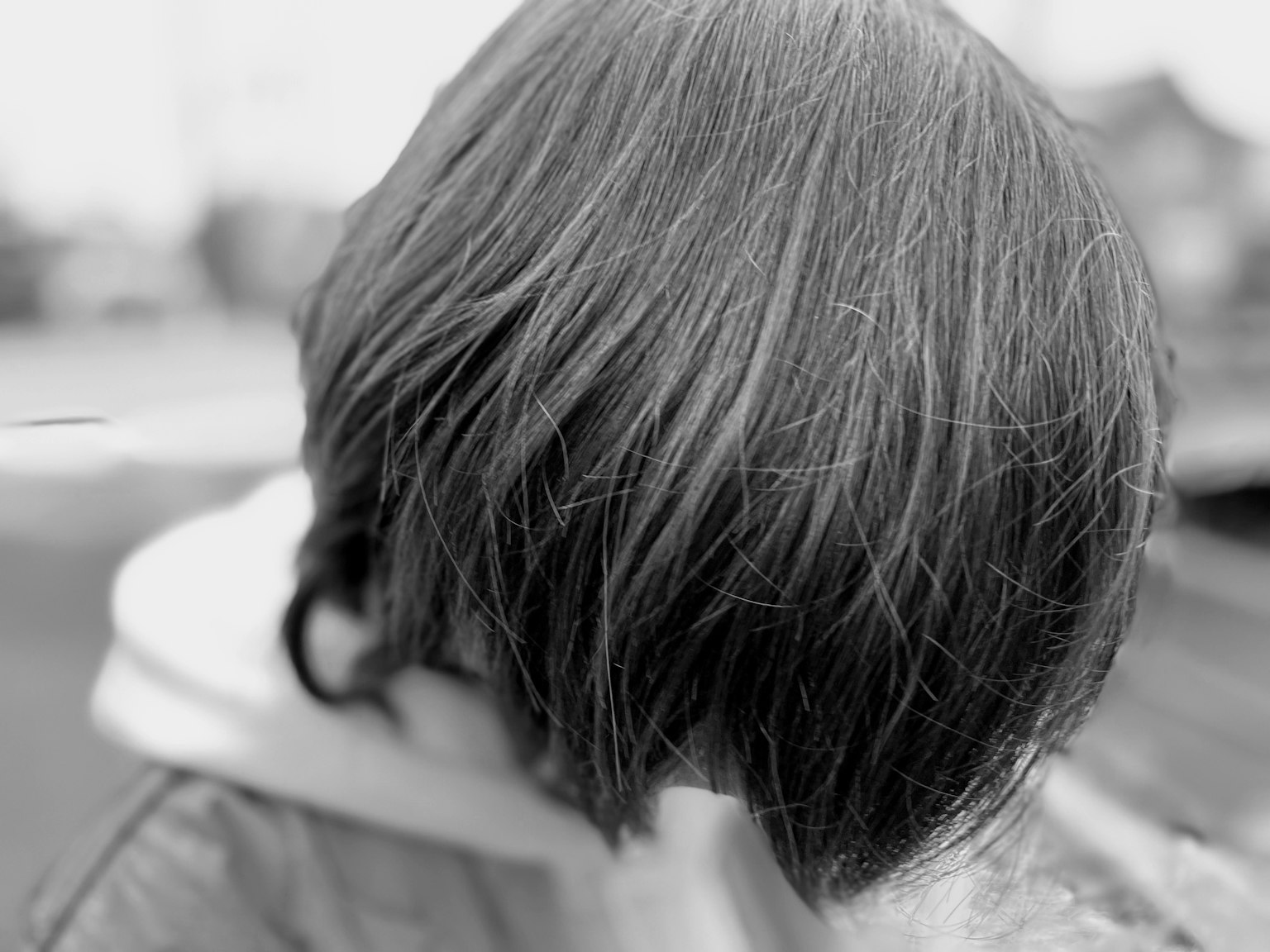Image en noir et blanc d'une personne avec une coiffure distinctive de dos