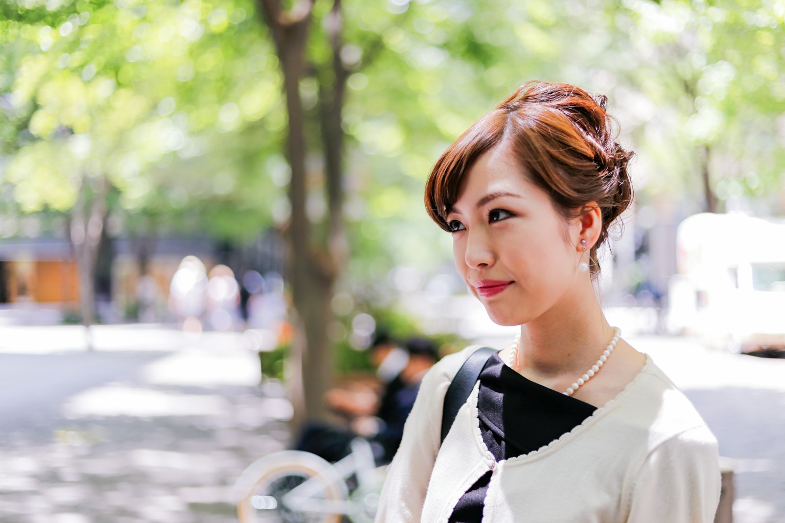 ภาพถ่ายหญิงสาวยิ้มใต้ต้นไม้สีเขียว