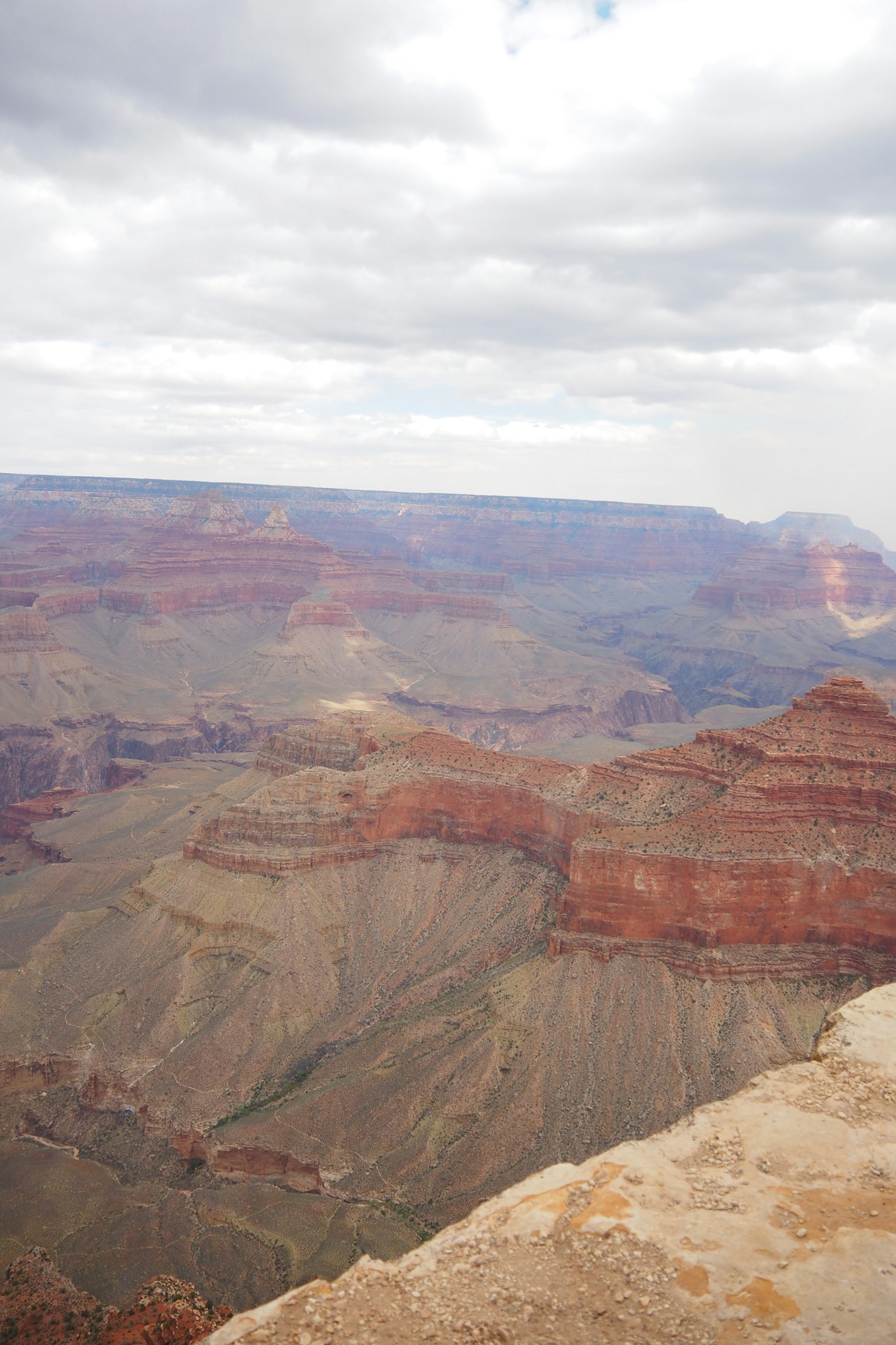 Vue spectaculaire du Grand Canyon avec des couches de roche rouge et un ciel nuageux