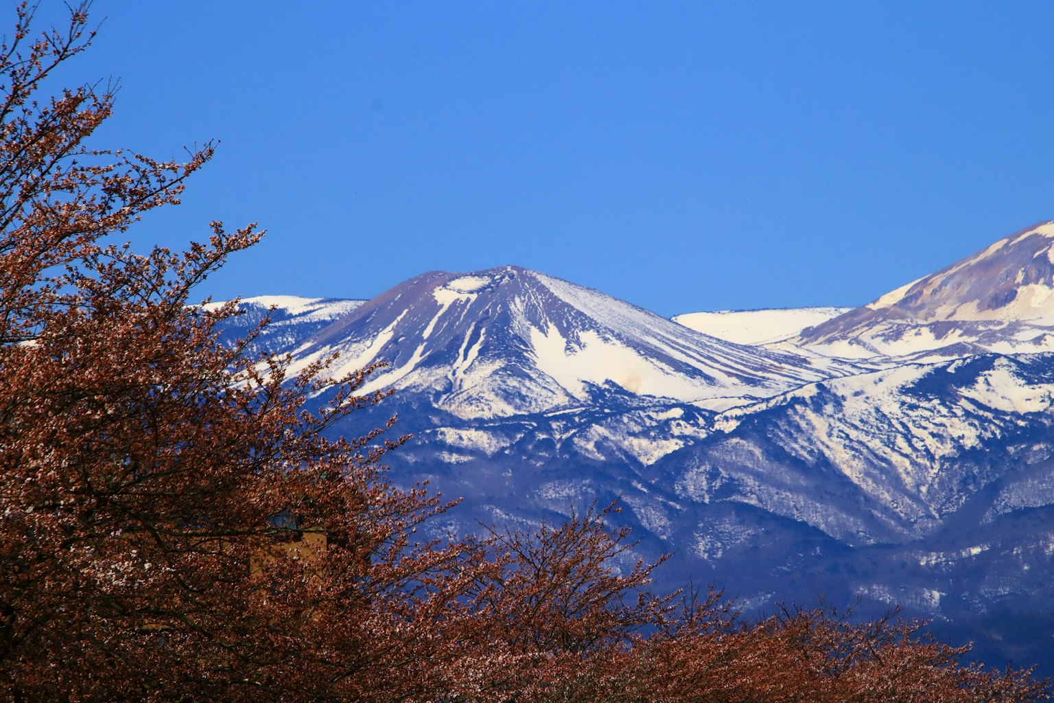 Snow-covered mountains under a clear blue sky