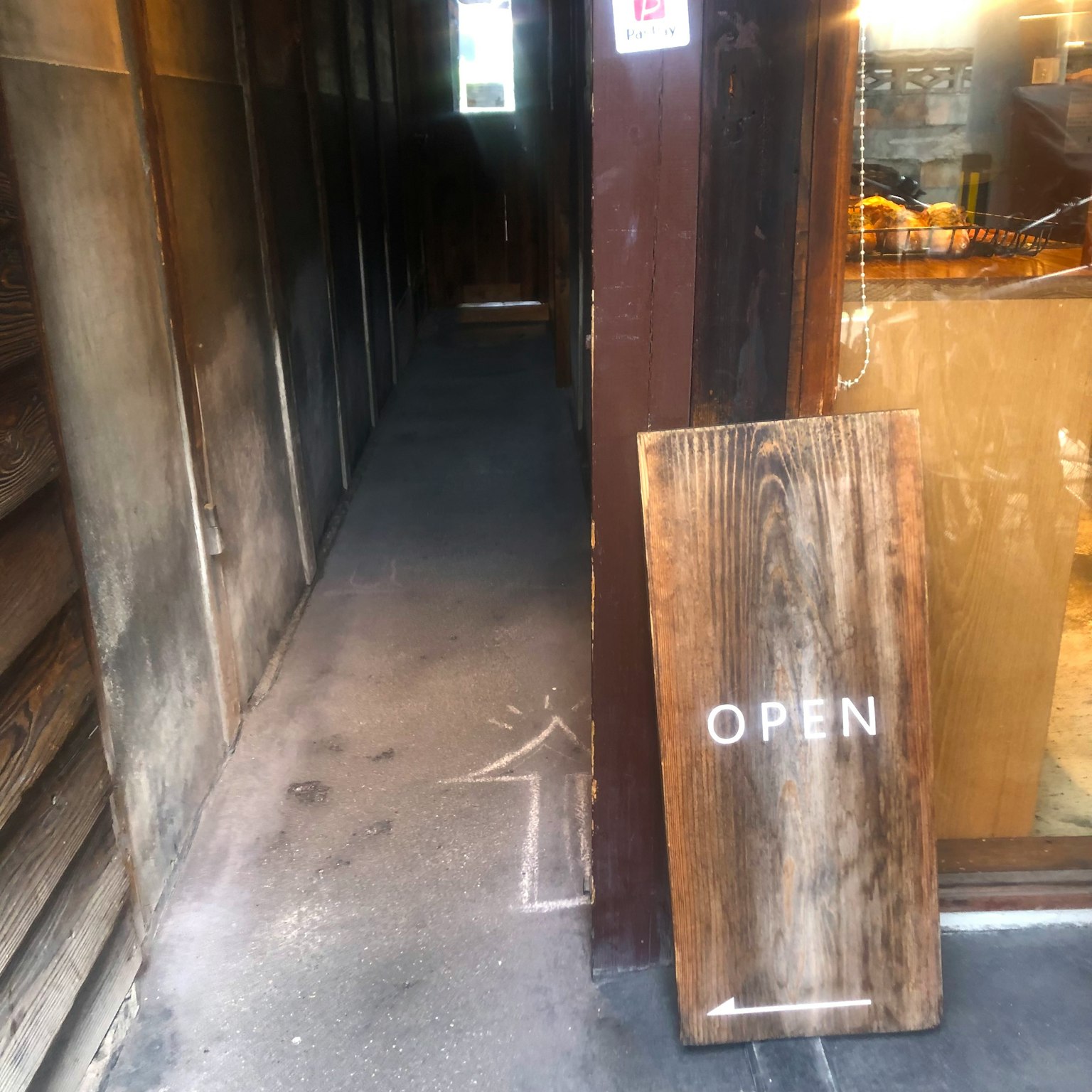 商店入口处有一个写着OPEN的木制标志
