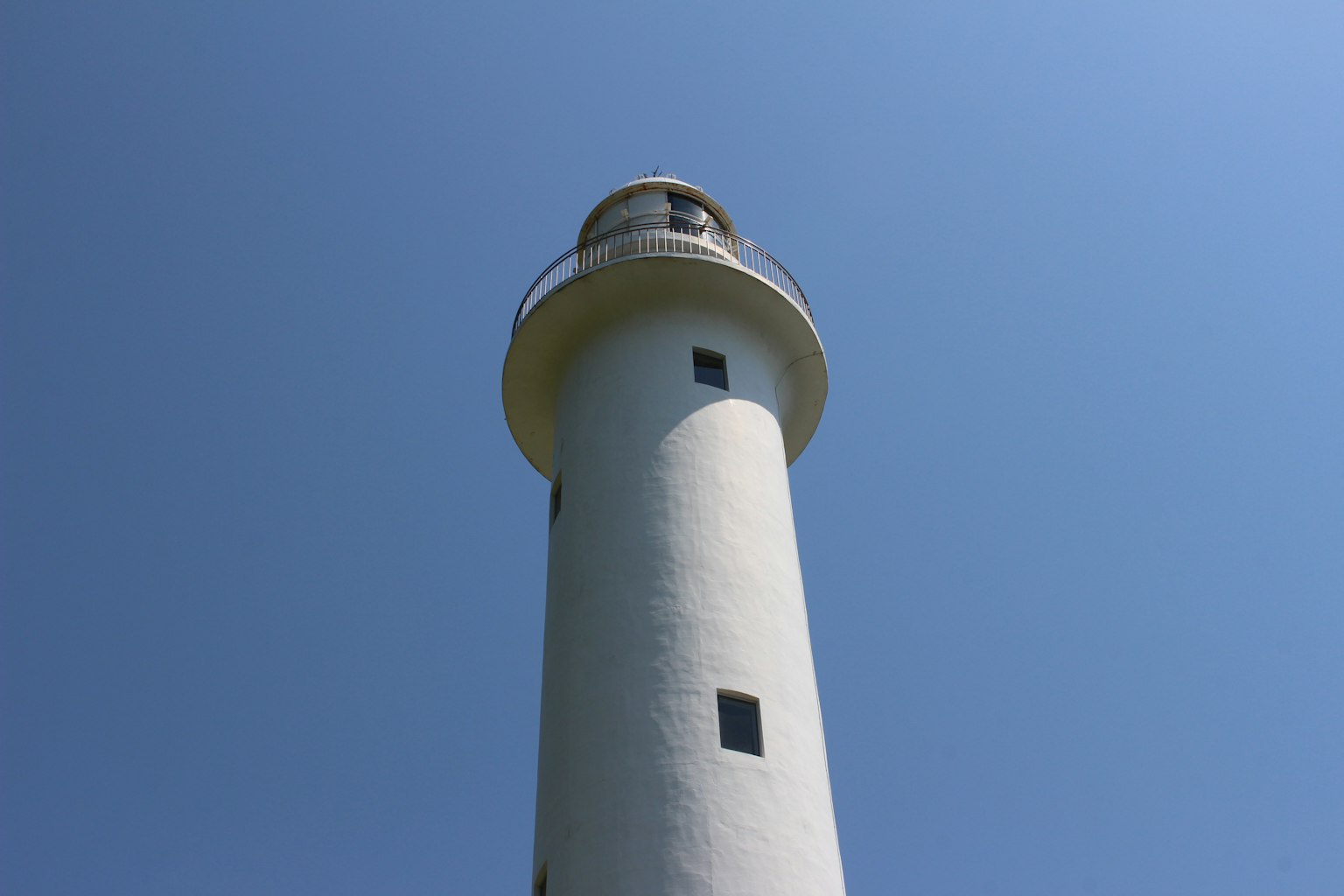 Un faro blanco que se eleva bajo un cielo azul