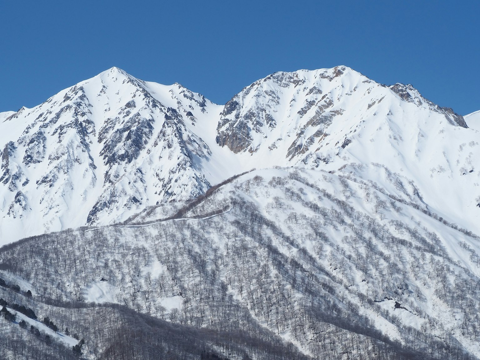Snow-covered mountain landscape under a blue sky