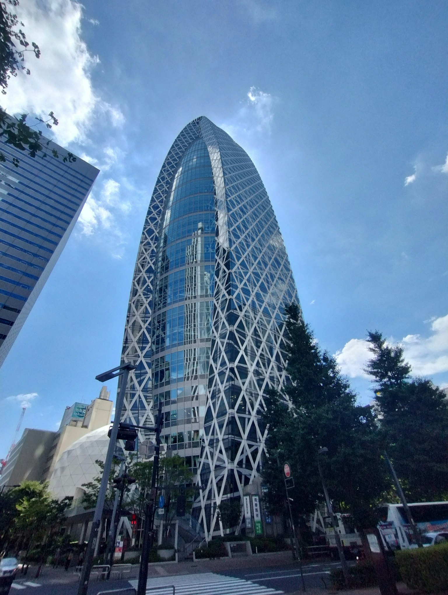 Edificio distintivo en Shinjuku con fachada de vidrio y metal bajo un cielo azul