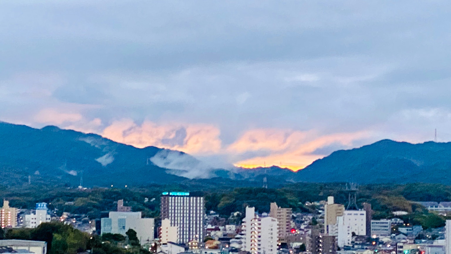 Stadtlandschaft mit Bergen bei Sonnenuntergang
