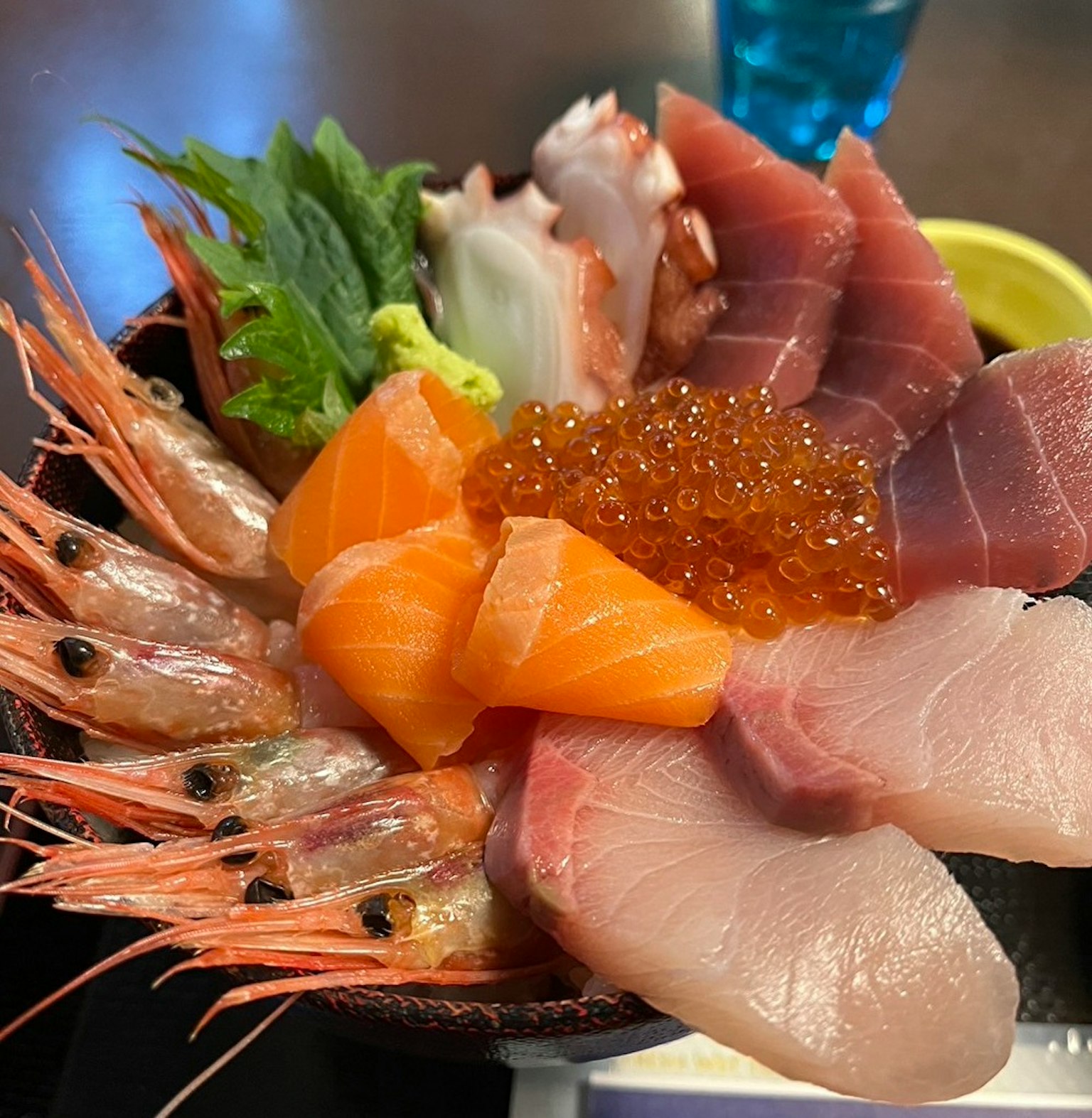 Un plateau de sashimi frais avec des crevettes du saumon de l'ikura et du thon joliment disposés