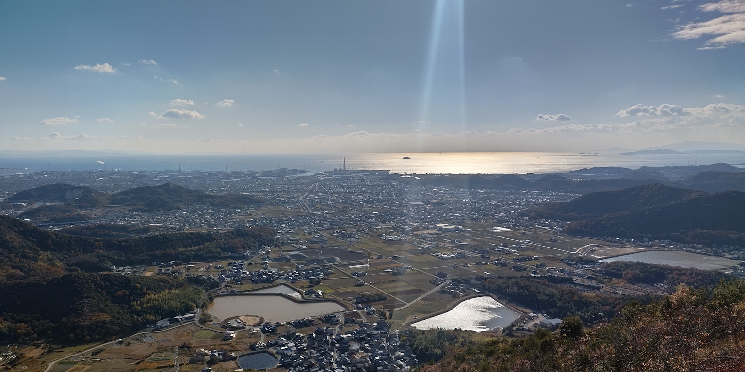 Vista panoramica di una città e dell'oceano da una cima montuosa