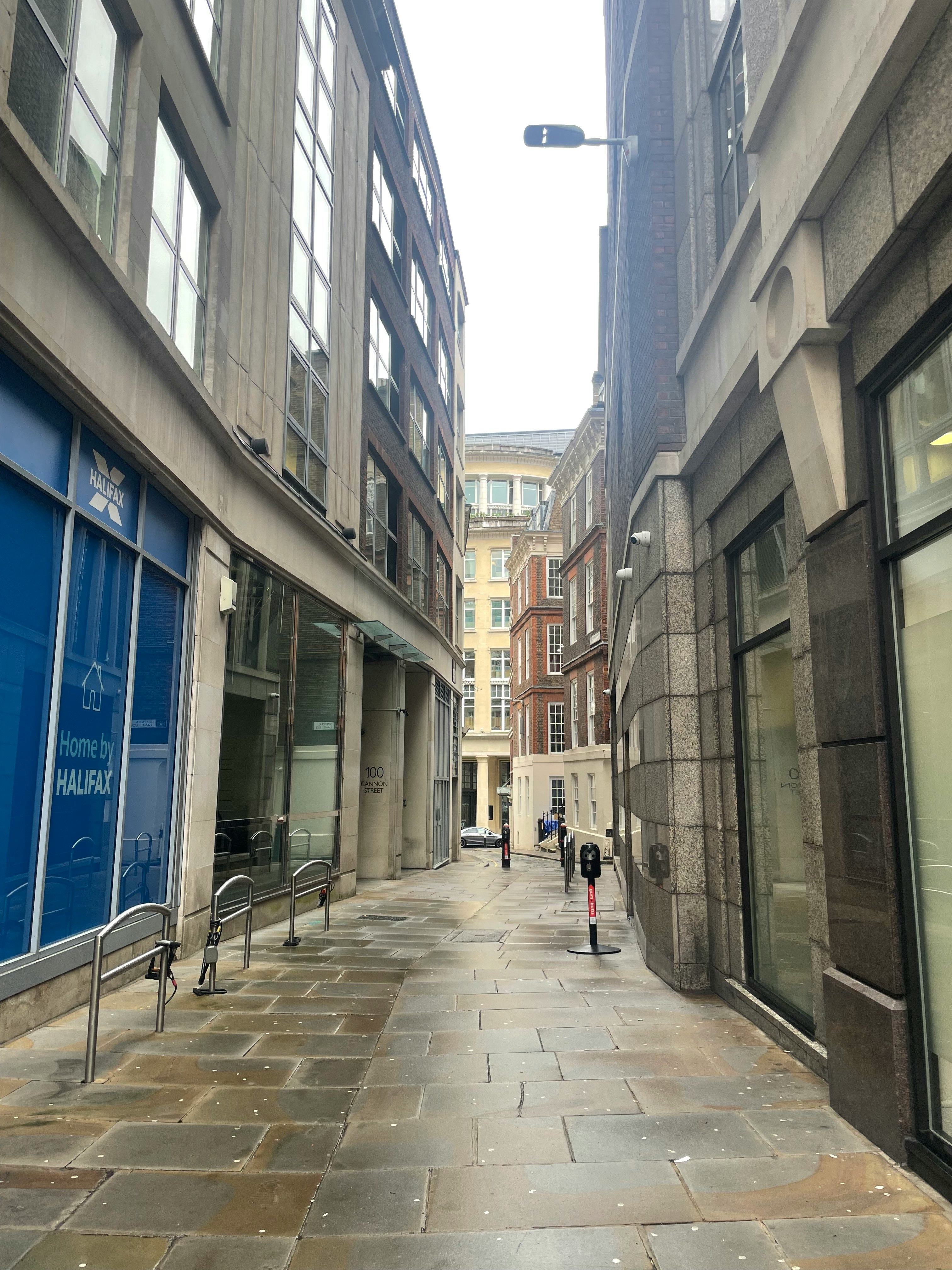 ロンドンの路地に面した石造りの商業ビルとガラス張りの店舗