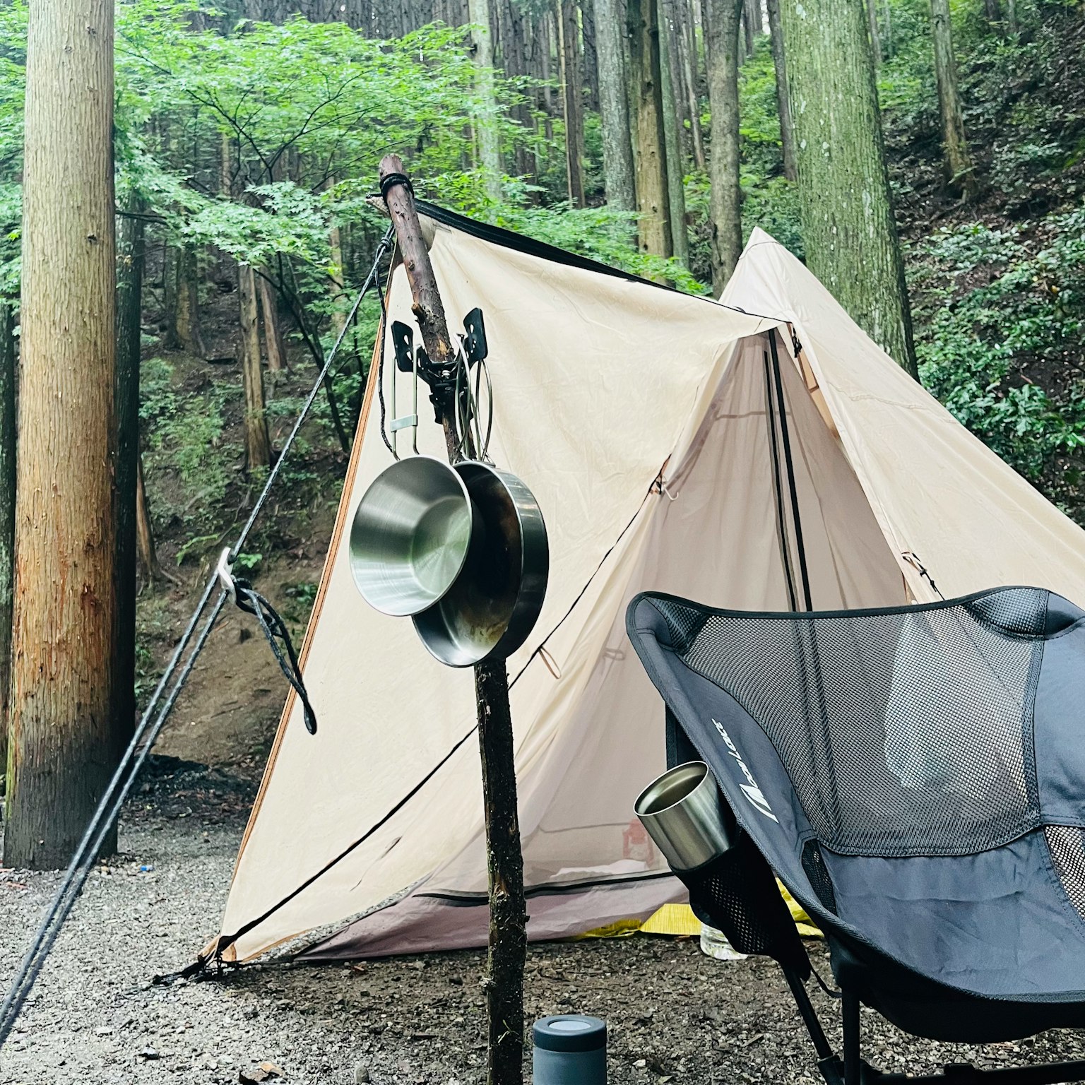 露營地有帳篷和懸掛鍋具的露營椅