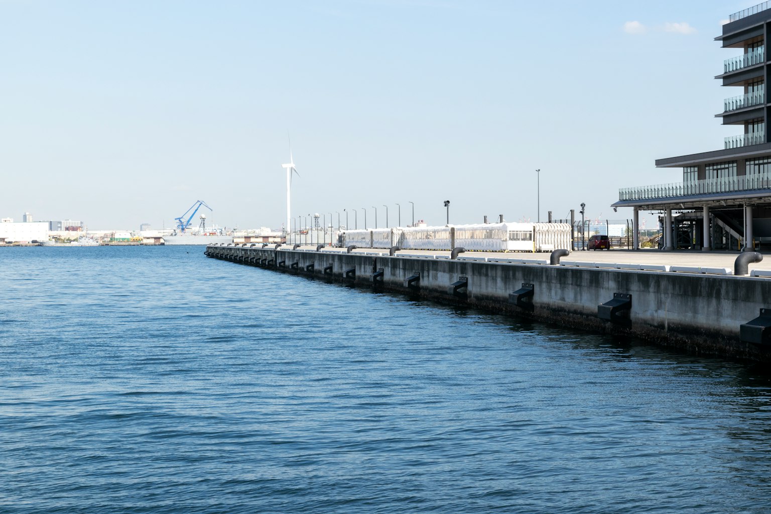 Pemandangan dermaga dengan air tenang dan langit biru cerah