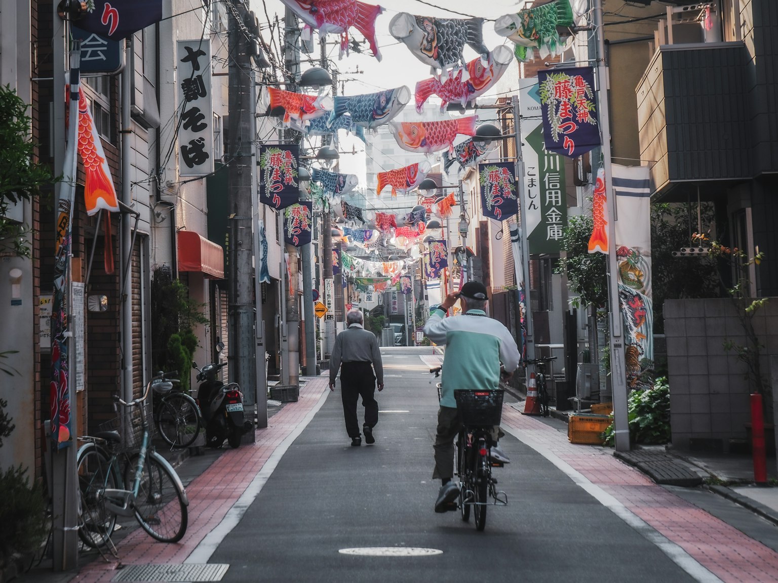 Escena de calle vibrante en un distrito comercial japonés con un ciclista y un peatón