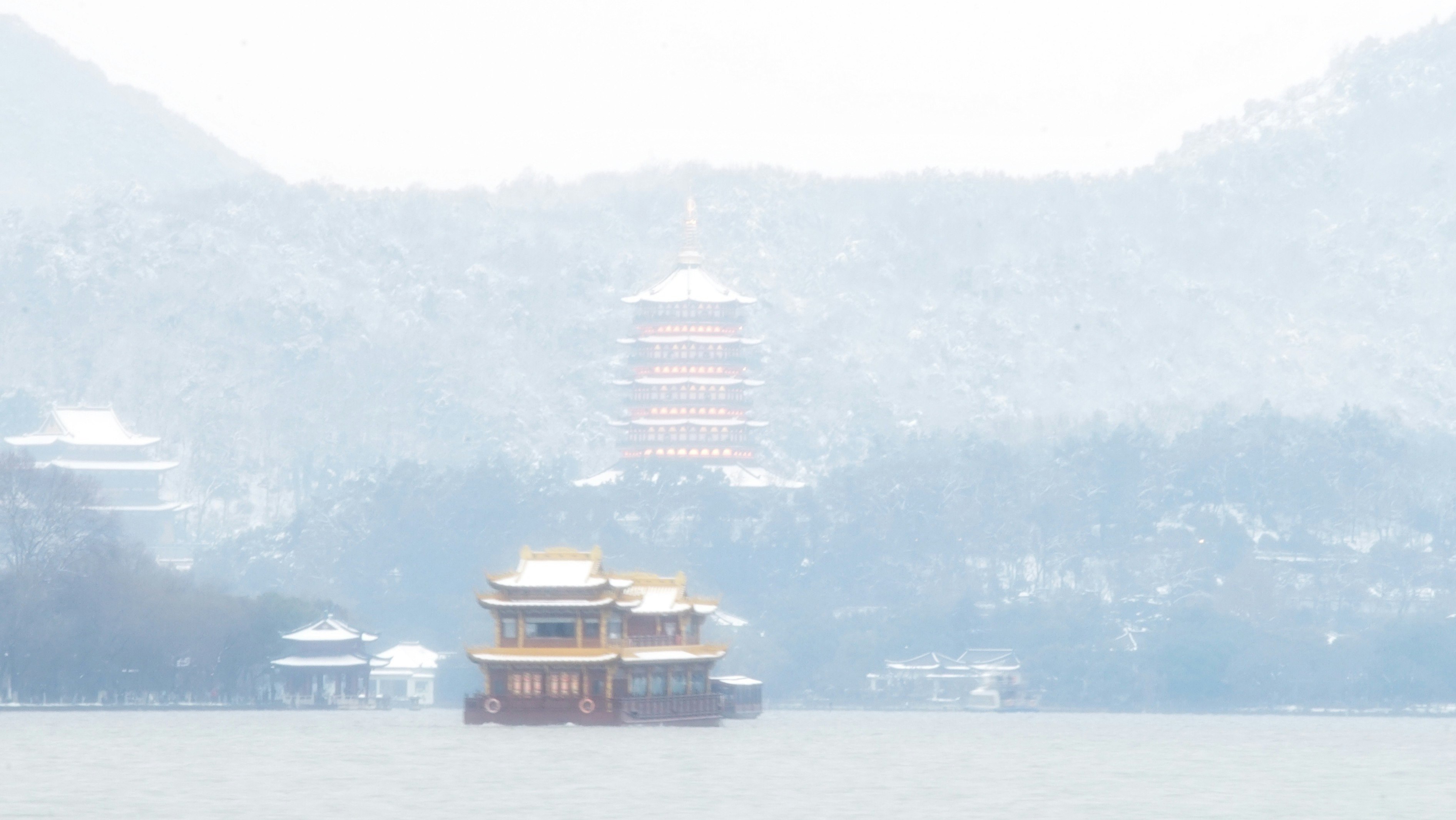 霧のかかった湖に浮かぶ寺院のような建物と山並み