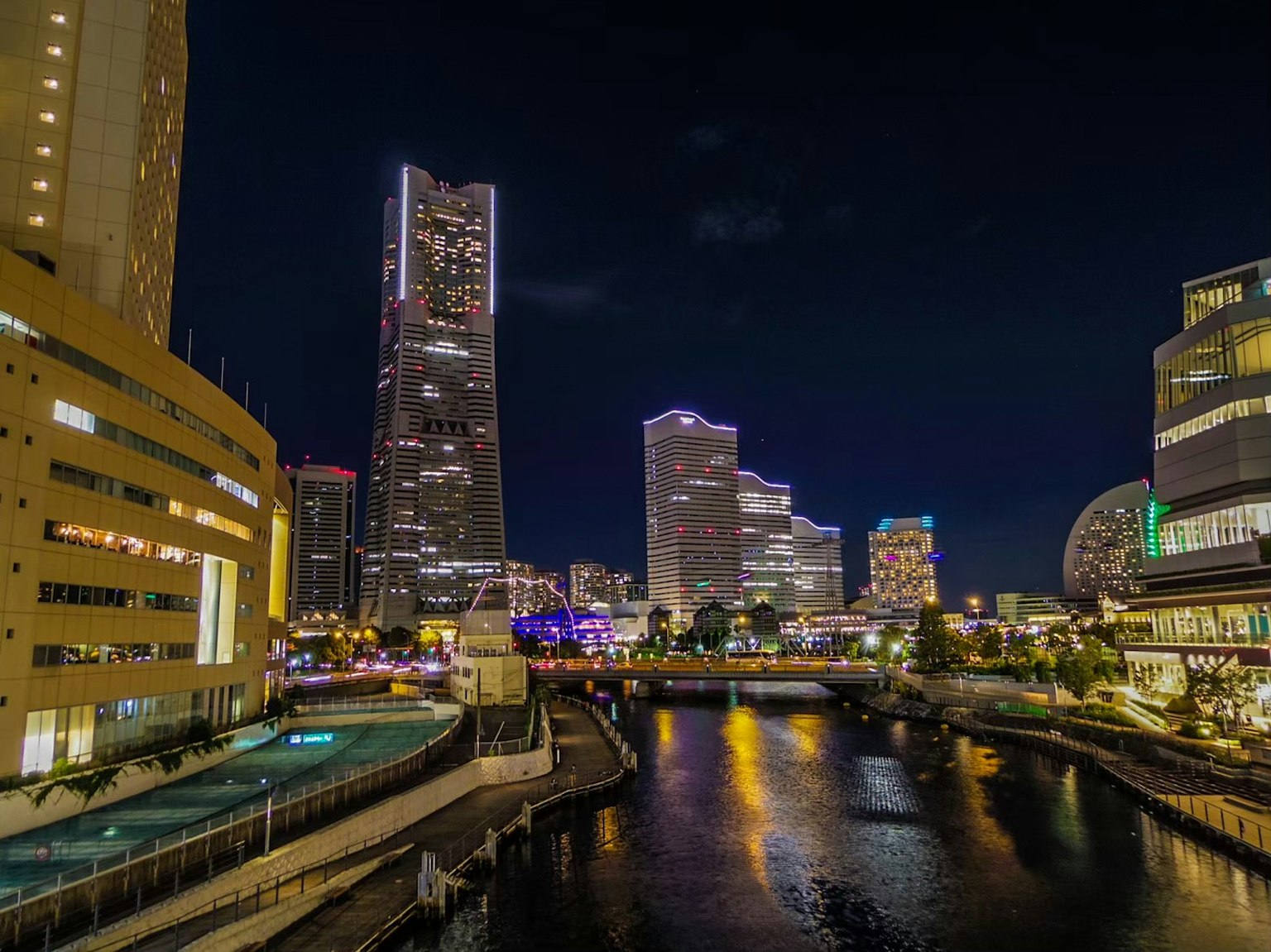 Nachtansicht der Skyline von Yokohama mit beleuchteten Gebäuden und Fluss