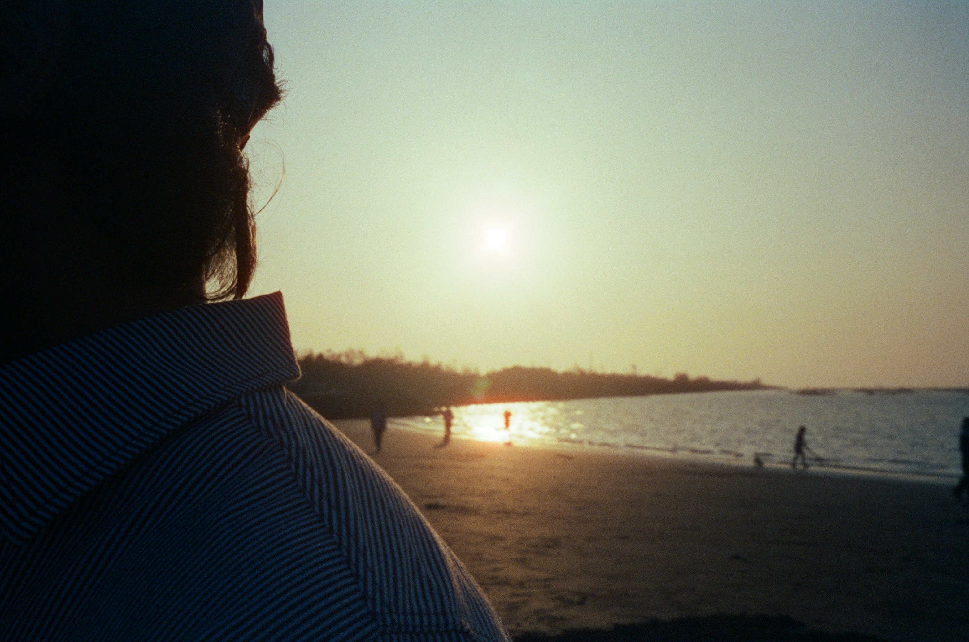 夕暮れの海辺を見つめる横顔