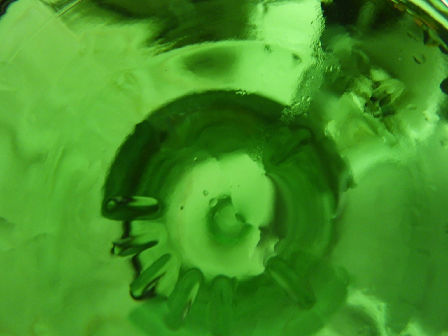 Scatto macro dettagliato del fondo di una bottiglia di vetro verde