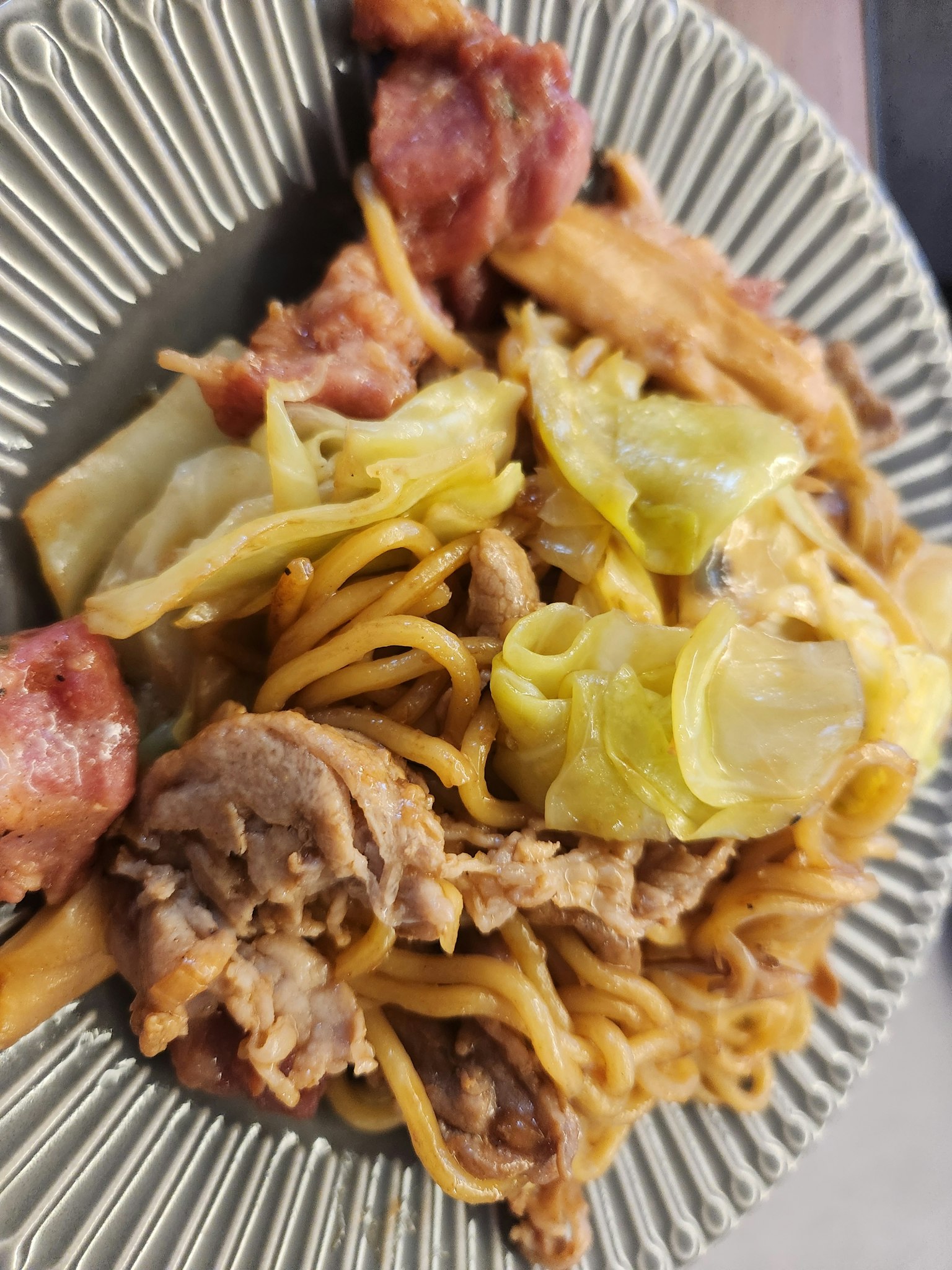 盤子裡的炒麵和高麗菜及肉類