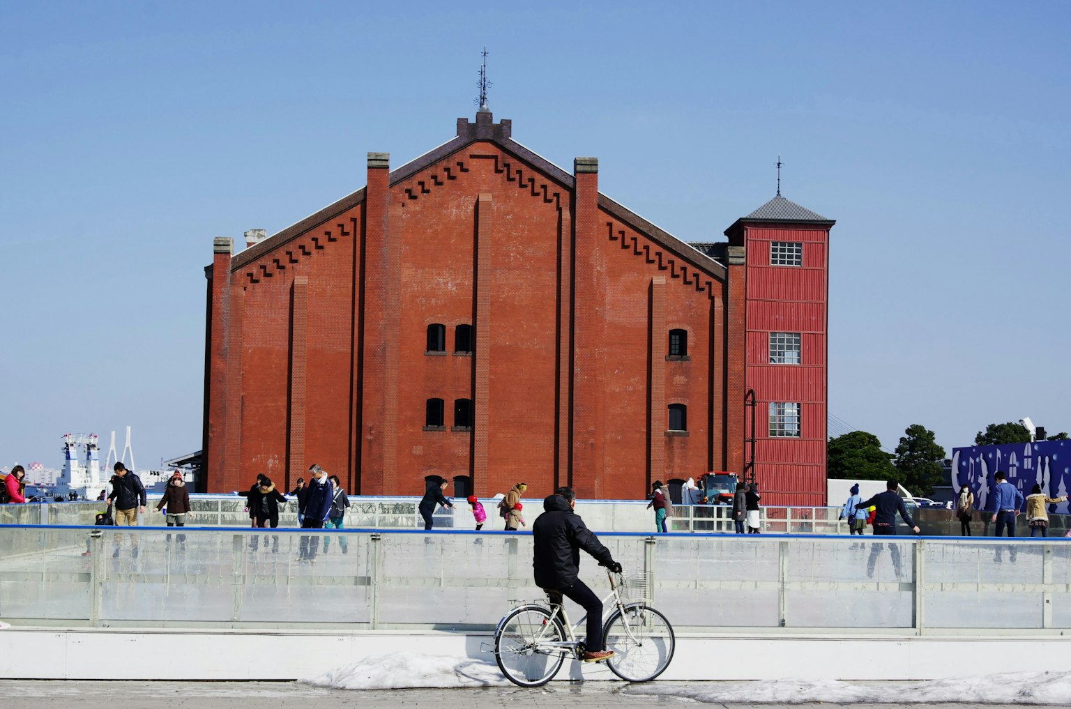 Urban scene featuring a red brick building and a person on a bicycle
