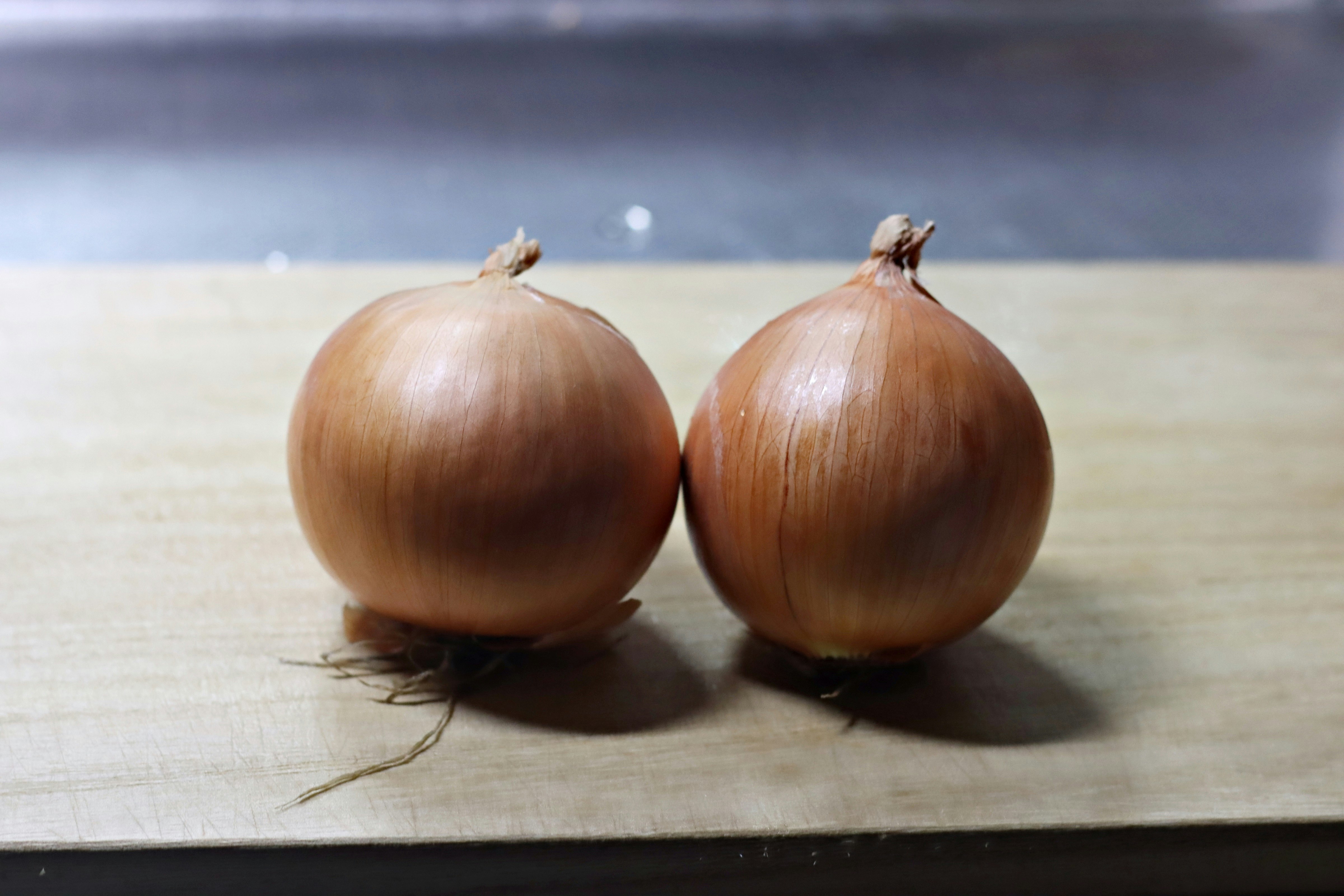 two onions on a wooden cutting board
