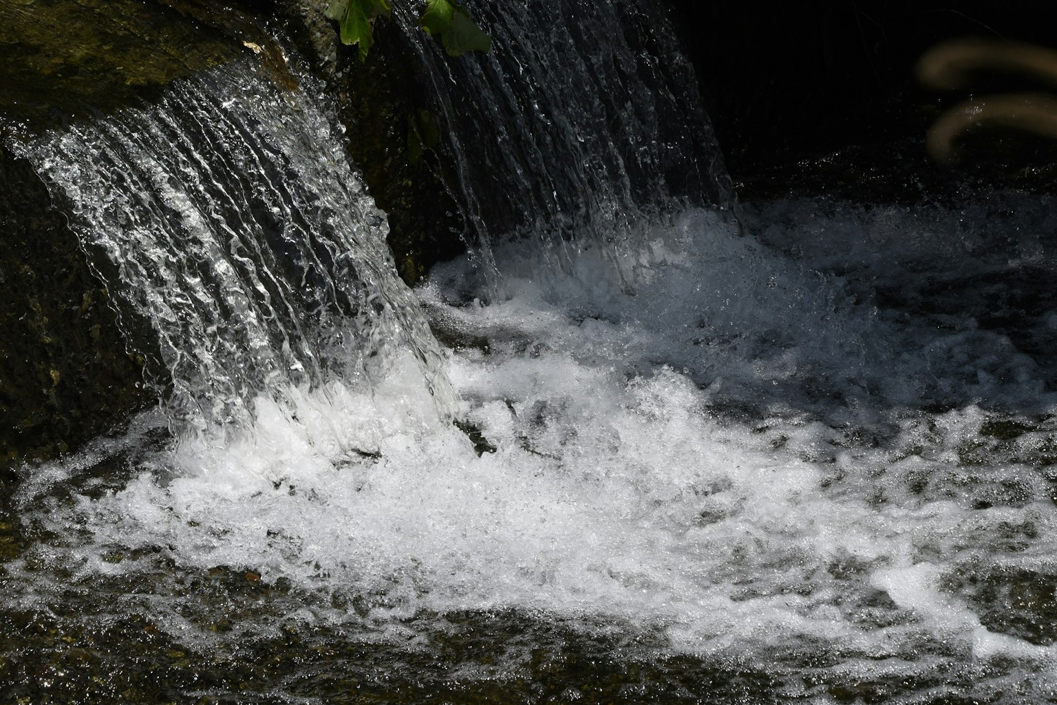 Kleiner Wasserfall mit fließendem Wasser und sprudelndem Schaum