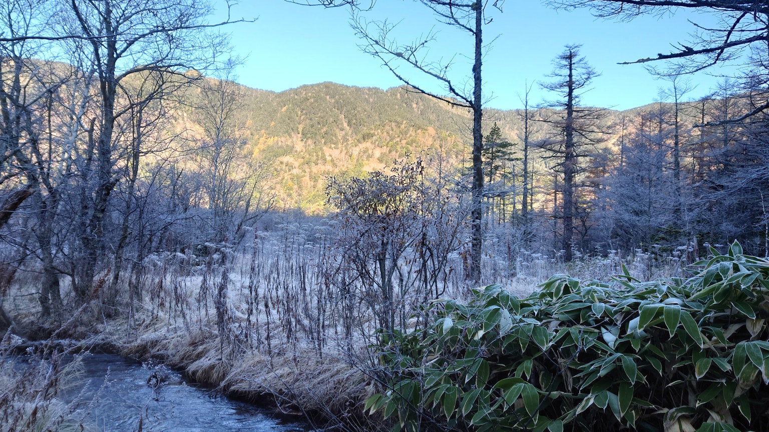 Paesaggio invernale con montagne e fiume ghiacciato