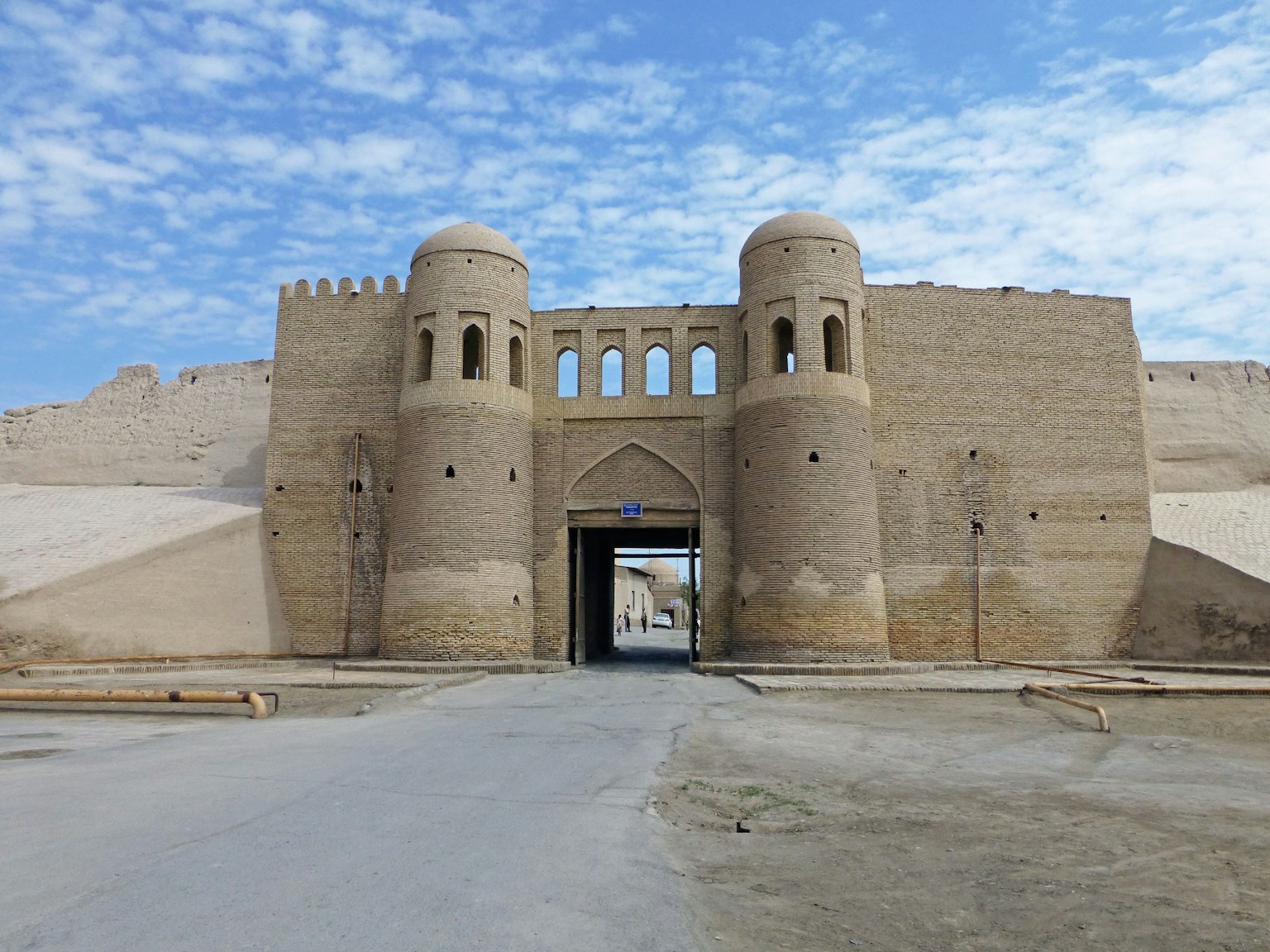Entrata di una antica fortezza nel deserto con muri e torri