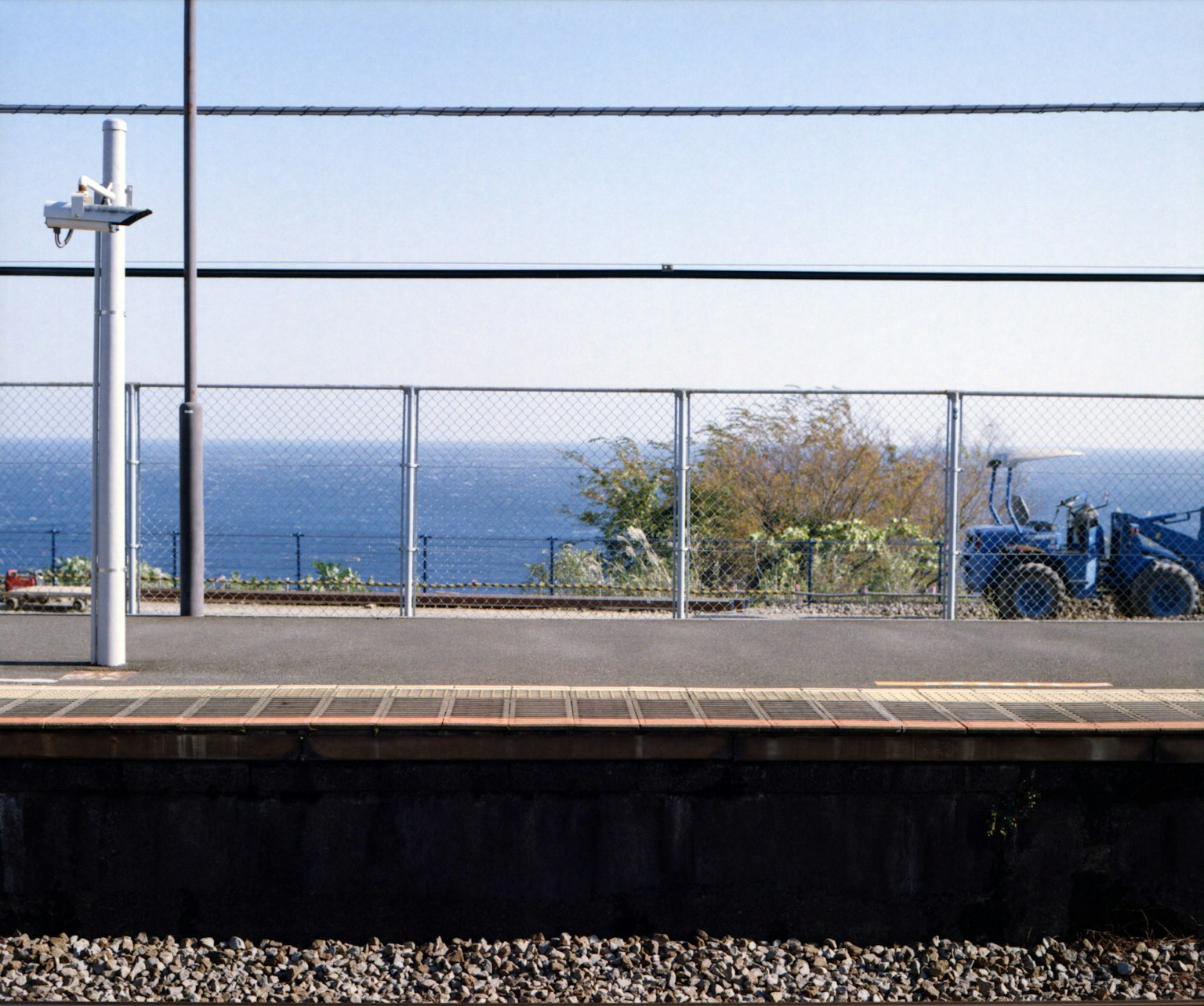 ชานชาลาสถานีรถไฟที่มองเห็นวิวทะเลและรั้ว