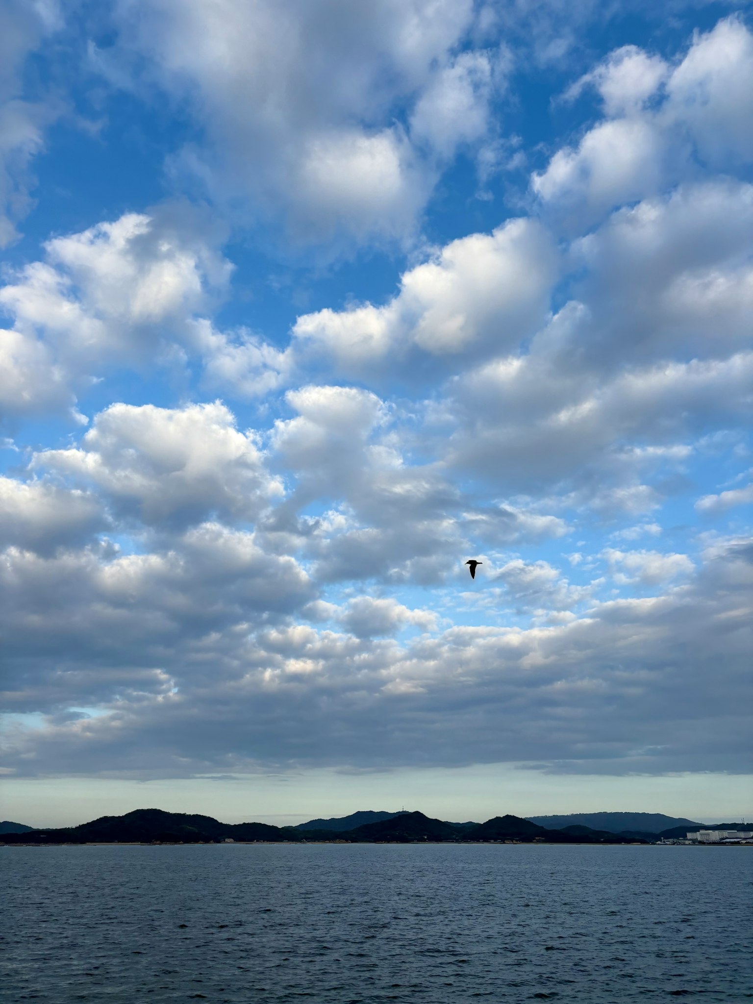 青空と白い雲が広がる海の風景 小さな島々が水面に浮かんでいる