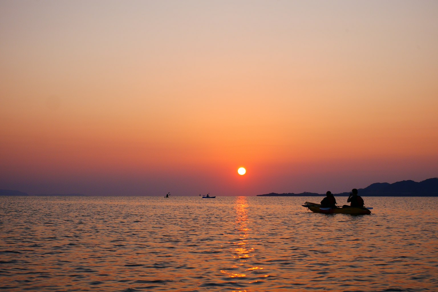 Hoàng hôn trên đại dương với người trong kayak