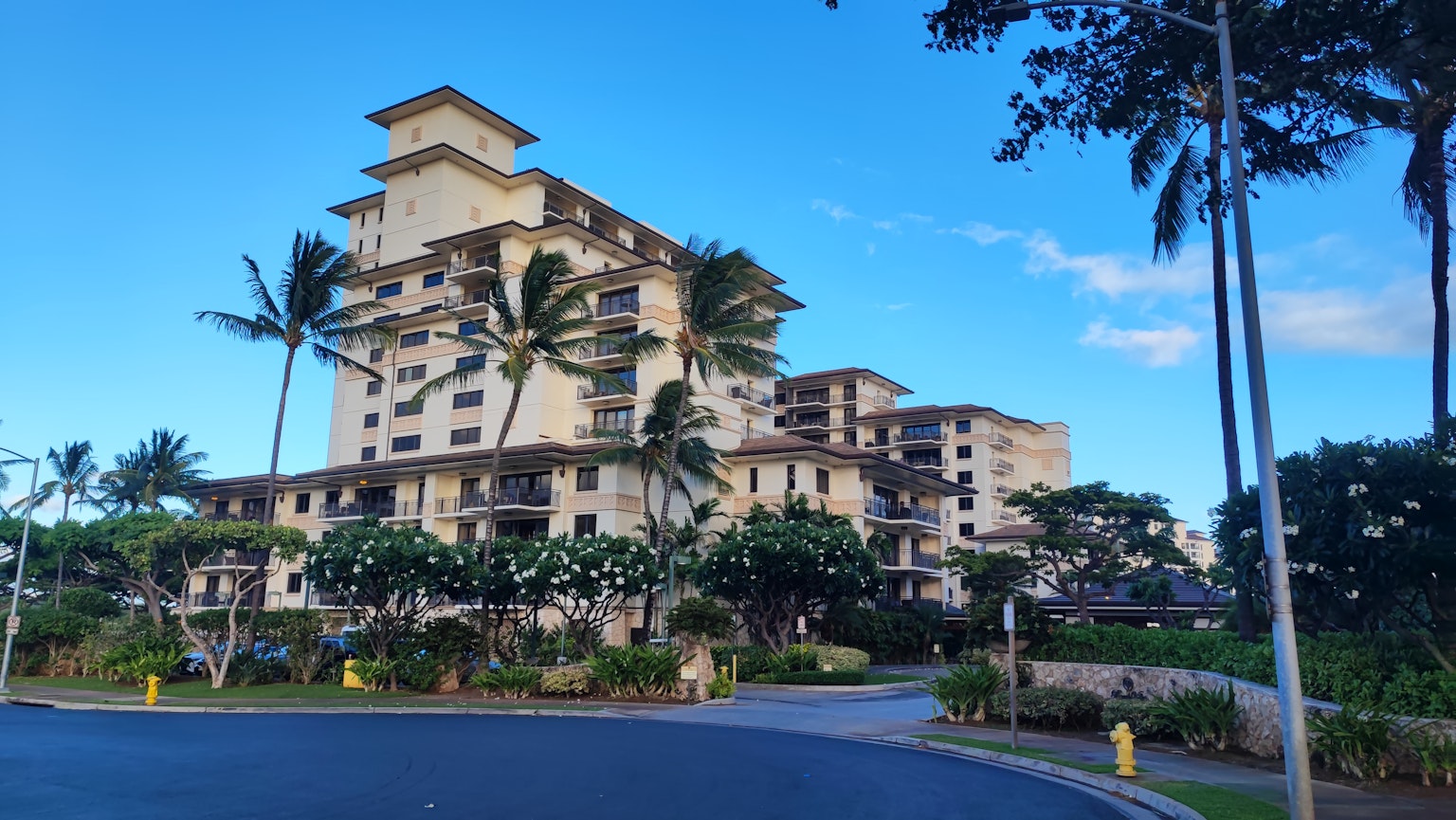 Edificio de estilo resort con palmeras bajo un cielo azul