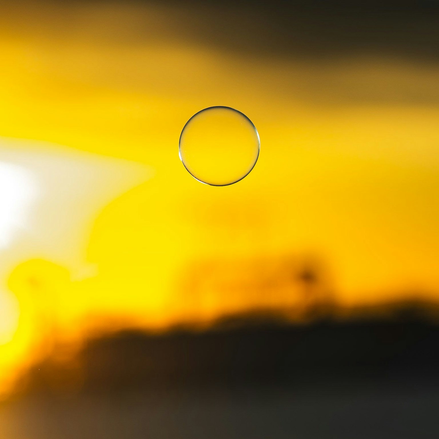 Primer plano de una burbuja transparente contra un fondo de atardecer