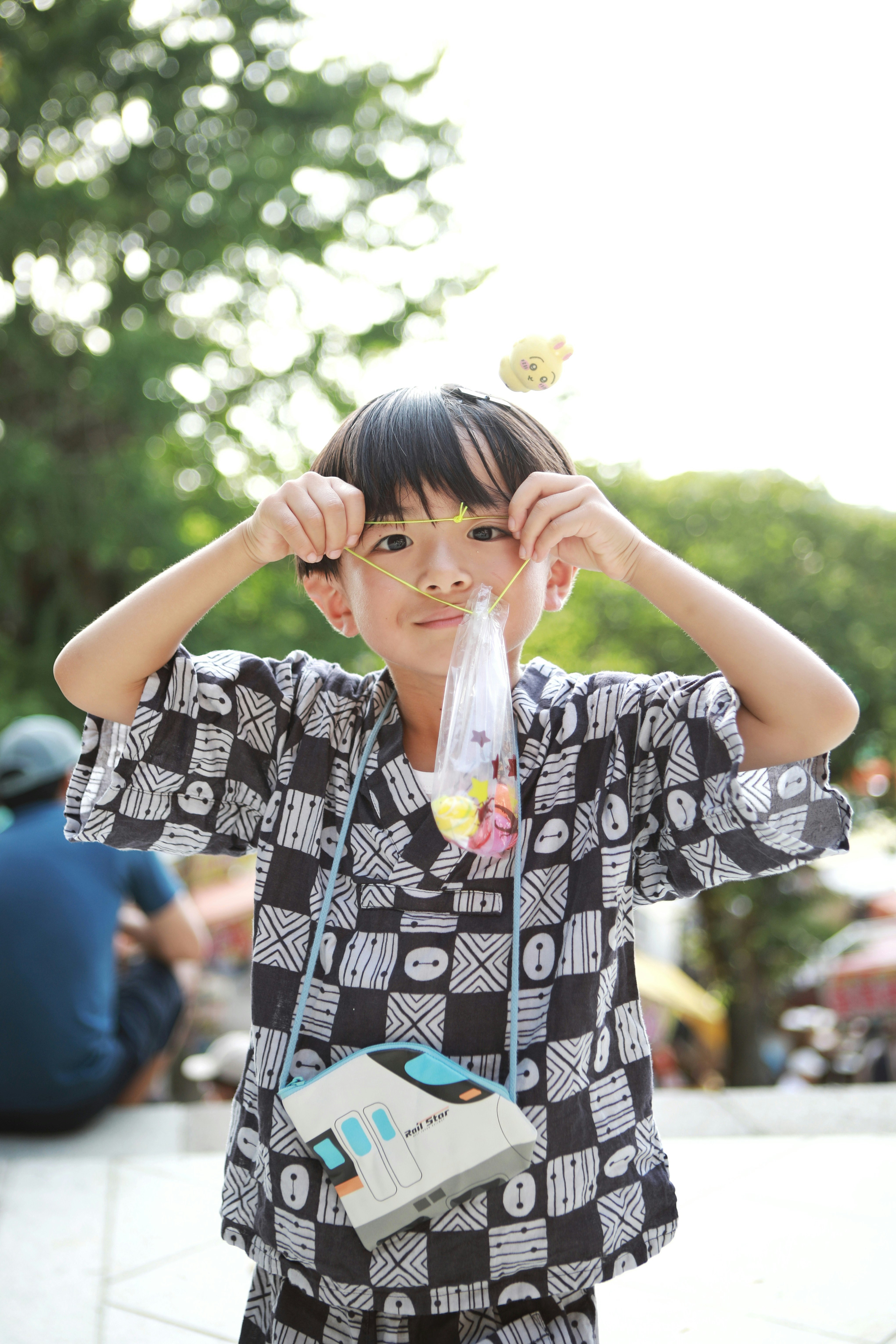 公園で両手で目の前にかざす子どもの笑顔