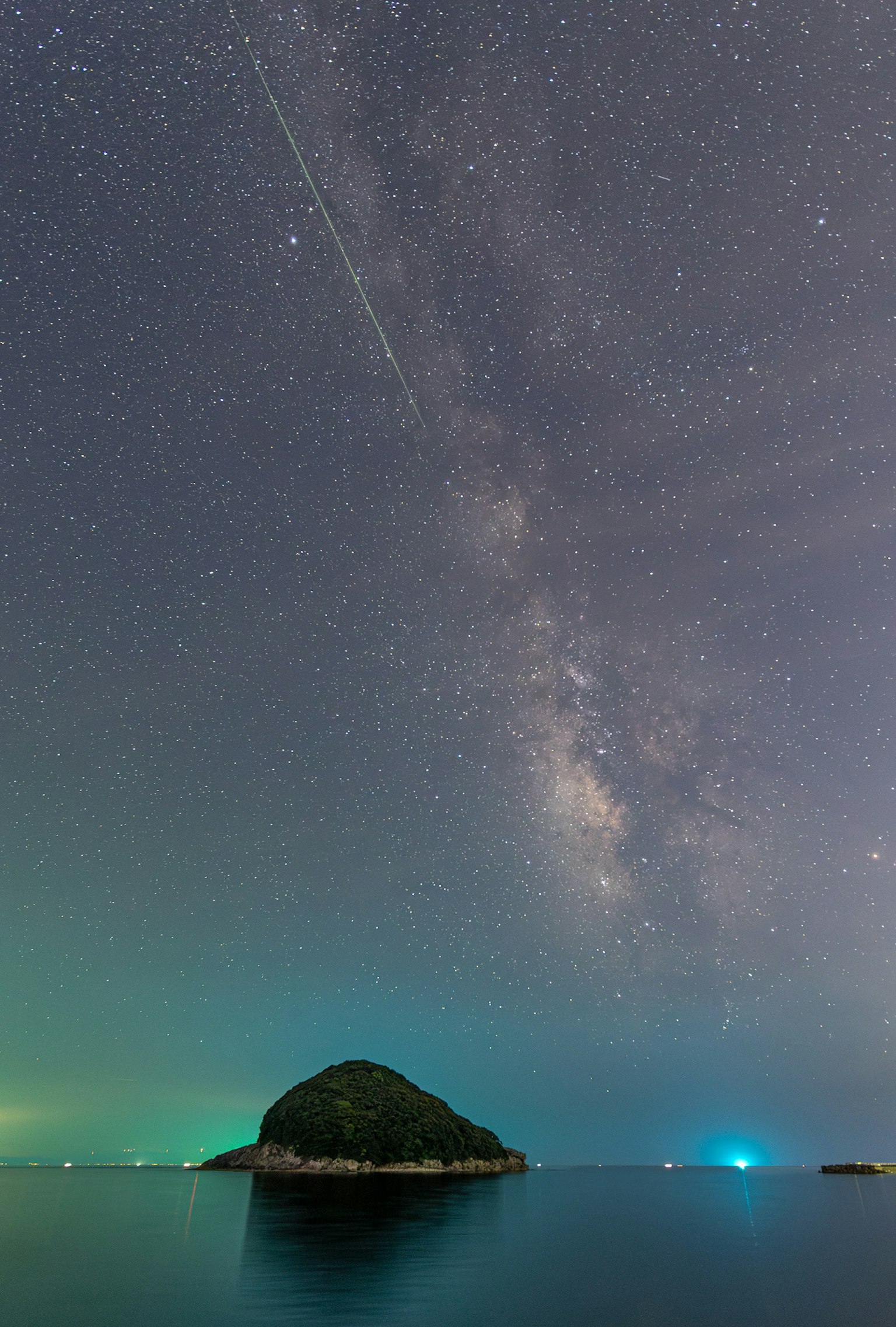 Una piccola isola sotto un cielo stellato con la Via Lattea visibile