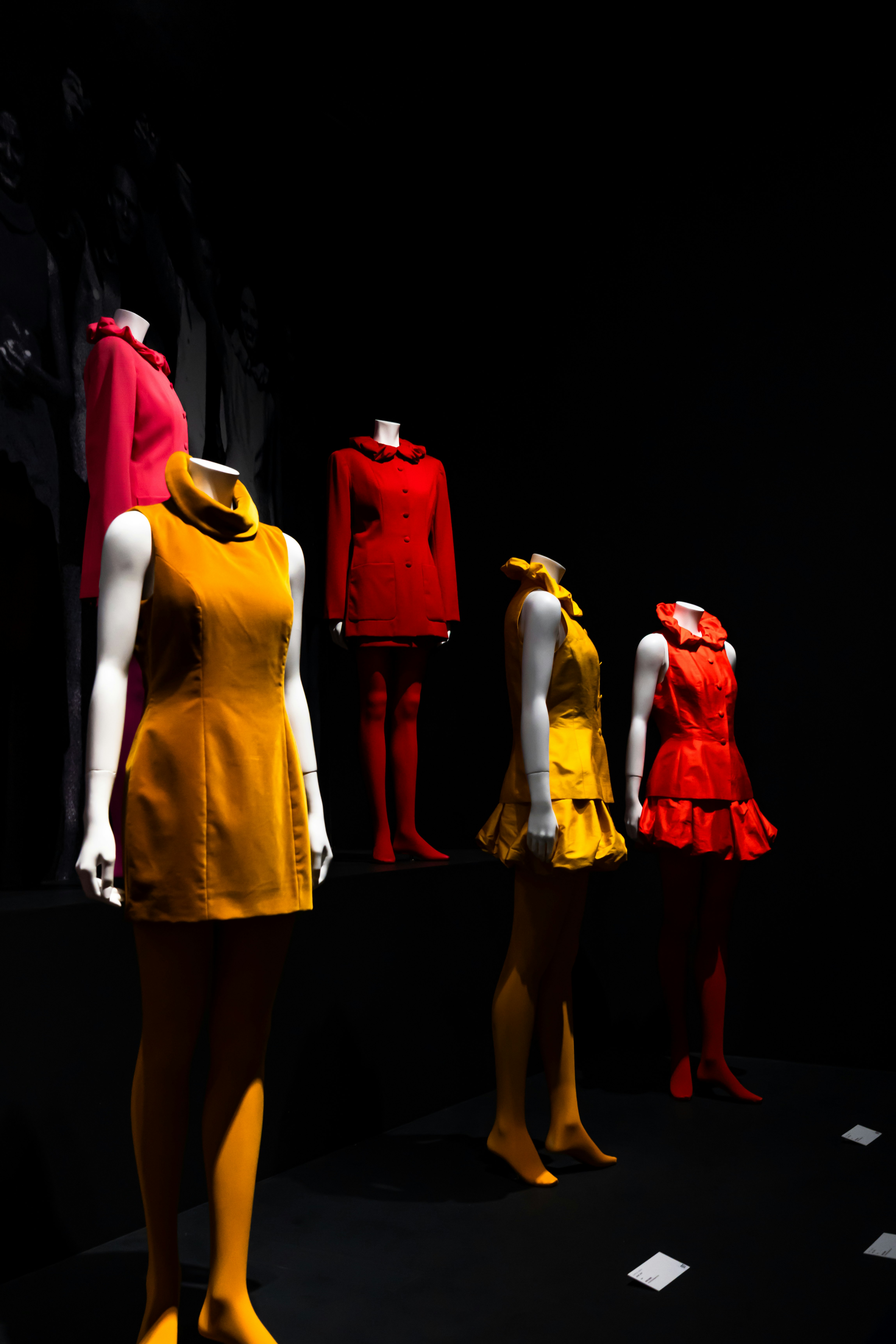 Mannequins et personnes en tenues rouges sur fond sombre