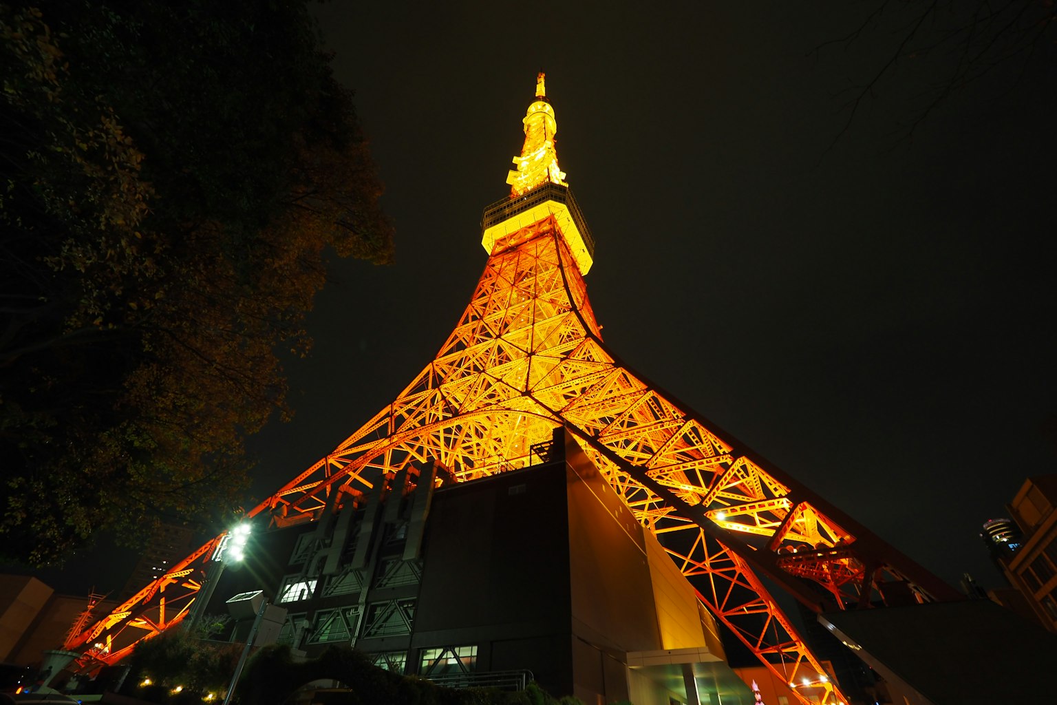 โตเกียวทาวเวอร์ส่องสว่างในตอนกลางคืนด้วยแสงสีส้มแสดงโครงสร้างของมัน