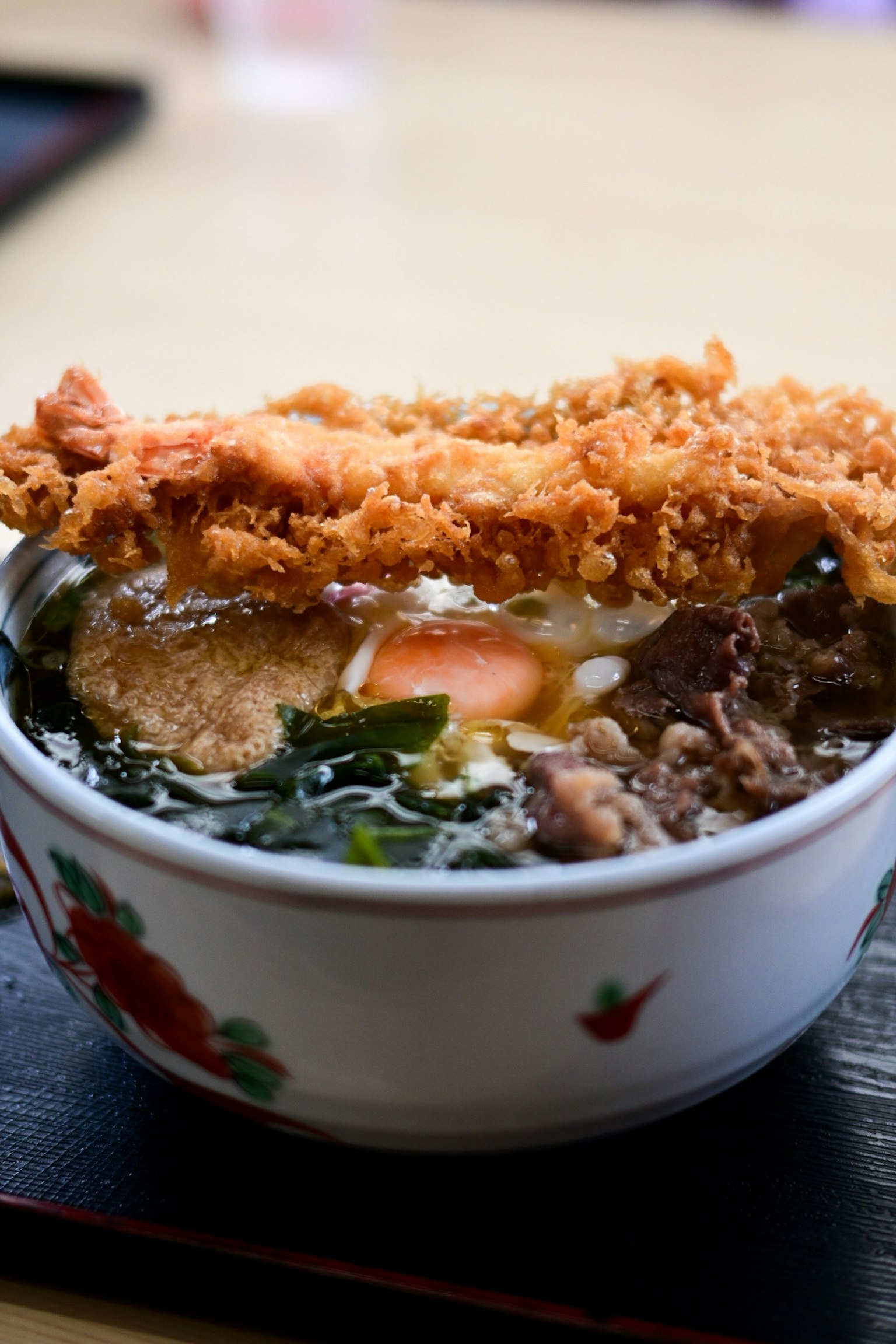 Semangkuk ramen lezat dengan makanan goreng di atasnya