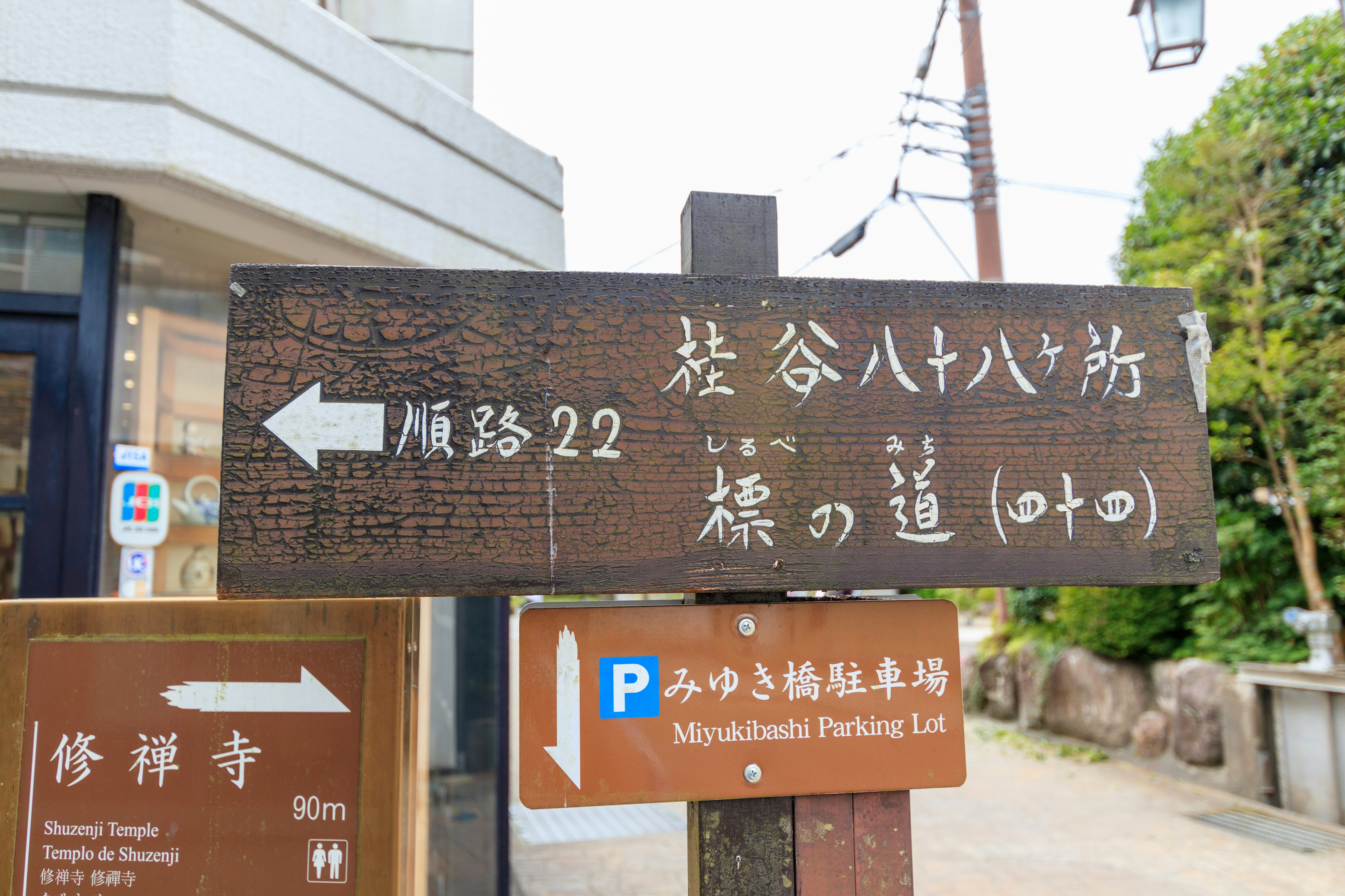 Entrance of a temple approach lined with route and Shūzenji signs